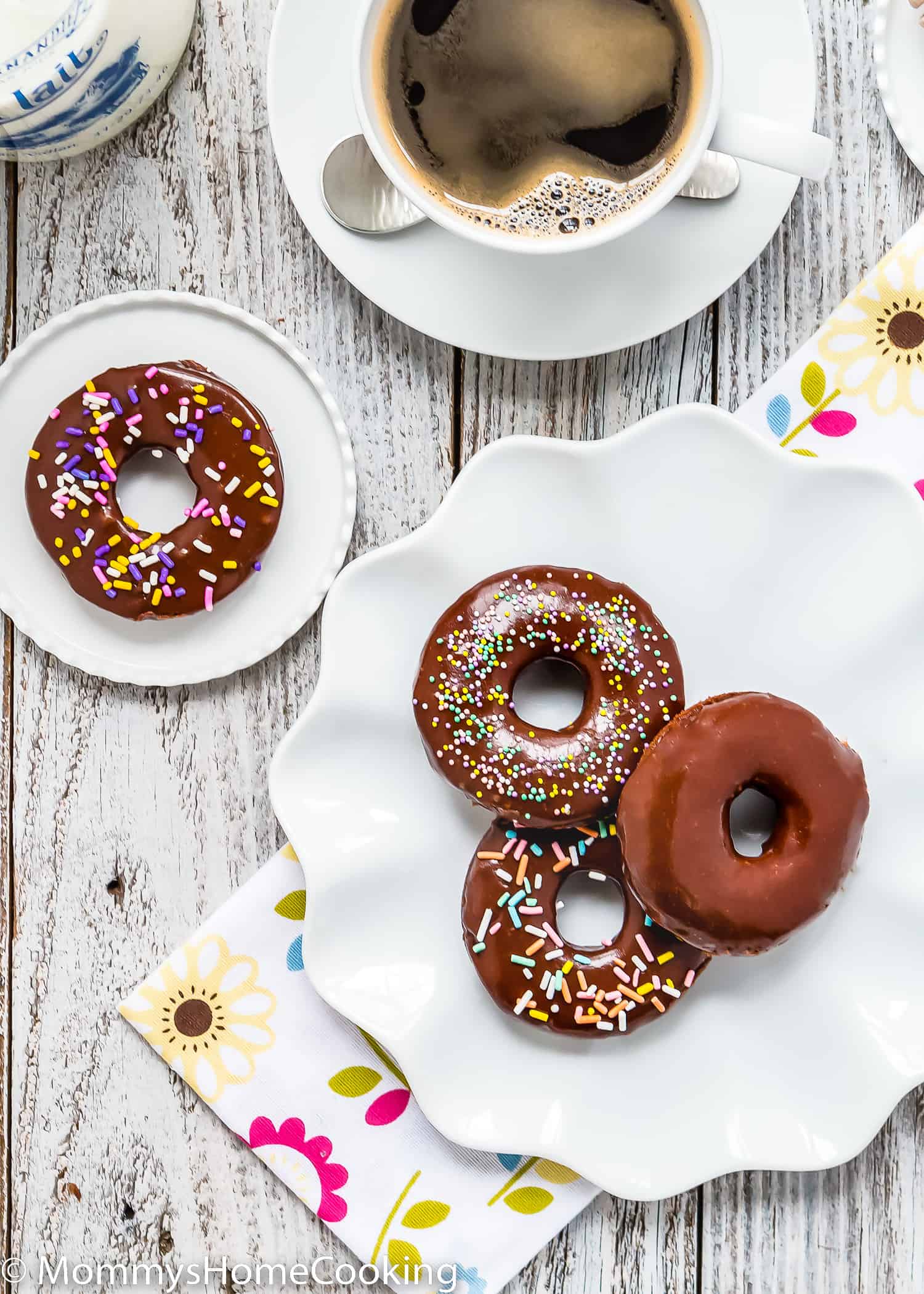 egg-free donuts in a plate with a cup of coffee on the side.