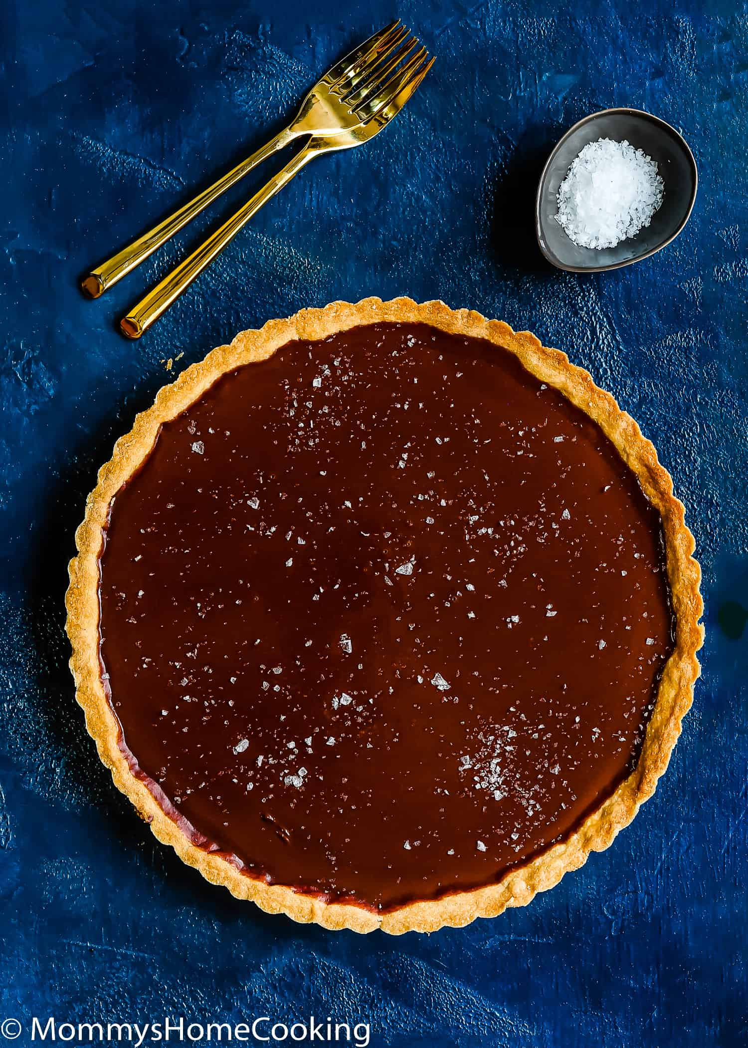 egg-free chocolate tart with sea salt flakes on top with two fork on the side.