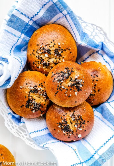 Eggless Honey Whole Wheat Rolls in a bread basket with a blue kitchen towel.