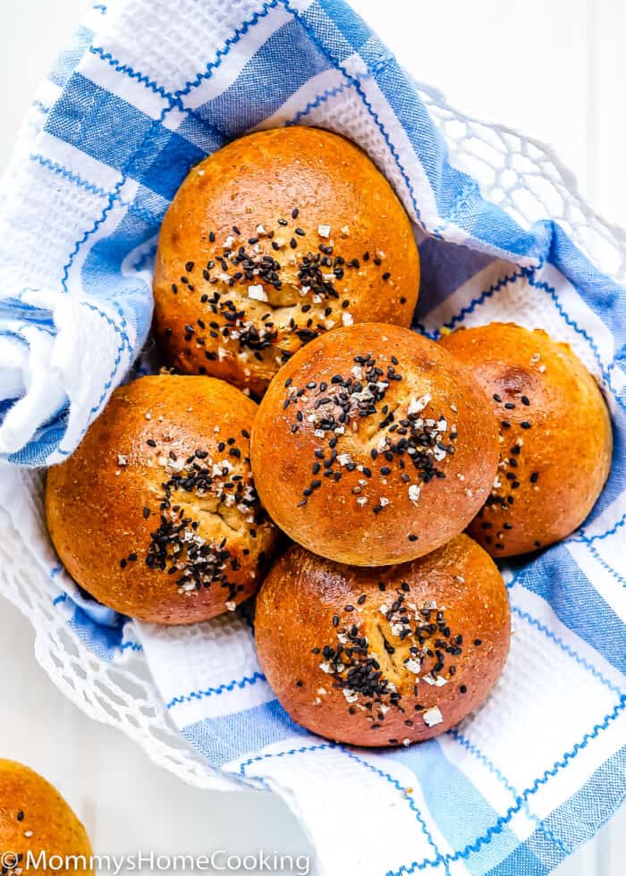 Eggless Honey Whole Wheat Rolls in a bread basket with a blue kitchen towel.