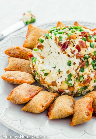 Bacon and Jalapeño Cheese Ball on a plate with pizza bites and a butter knife on the side.