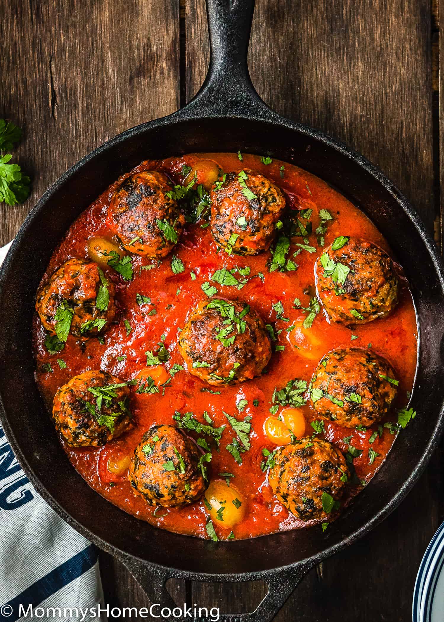 egg-free turkey meatballs with marinara sauce in a skillet over a wooden surface.
