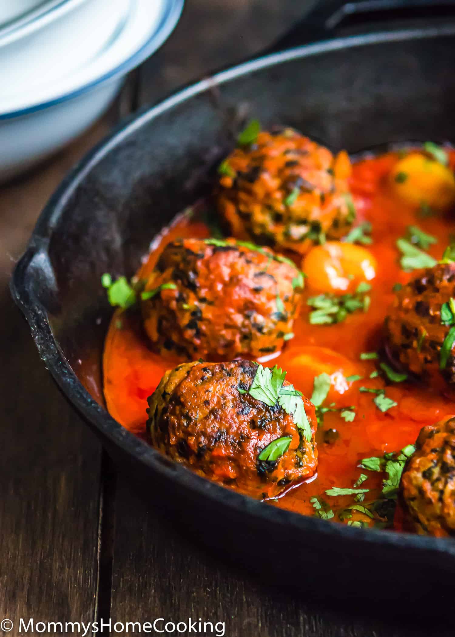 egg-free turkey meatballs with marinara sauce in a skillet with chopped basil.