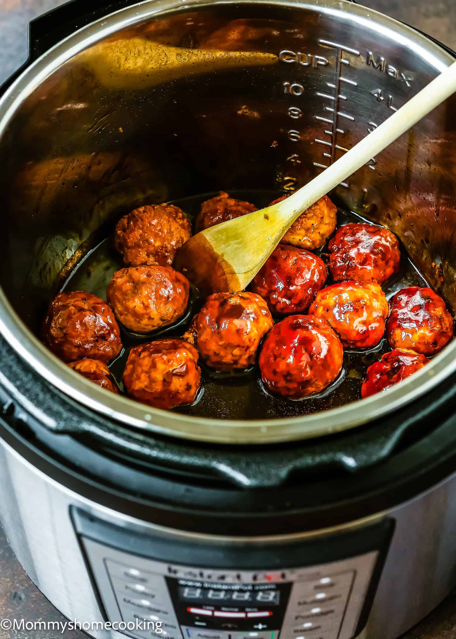 Easy Teriyaki Turkey Meatballs shimmer in a glossy sauce as they are gently stirred with a wooden spoon inside an electric pressure cooker. This egg-free delight simplifies dinner while delivering all the flavorful richness you crave.