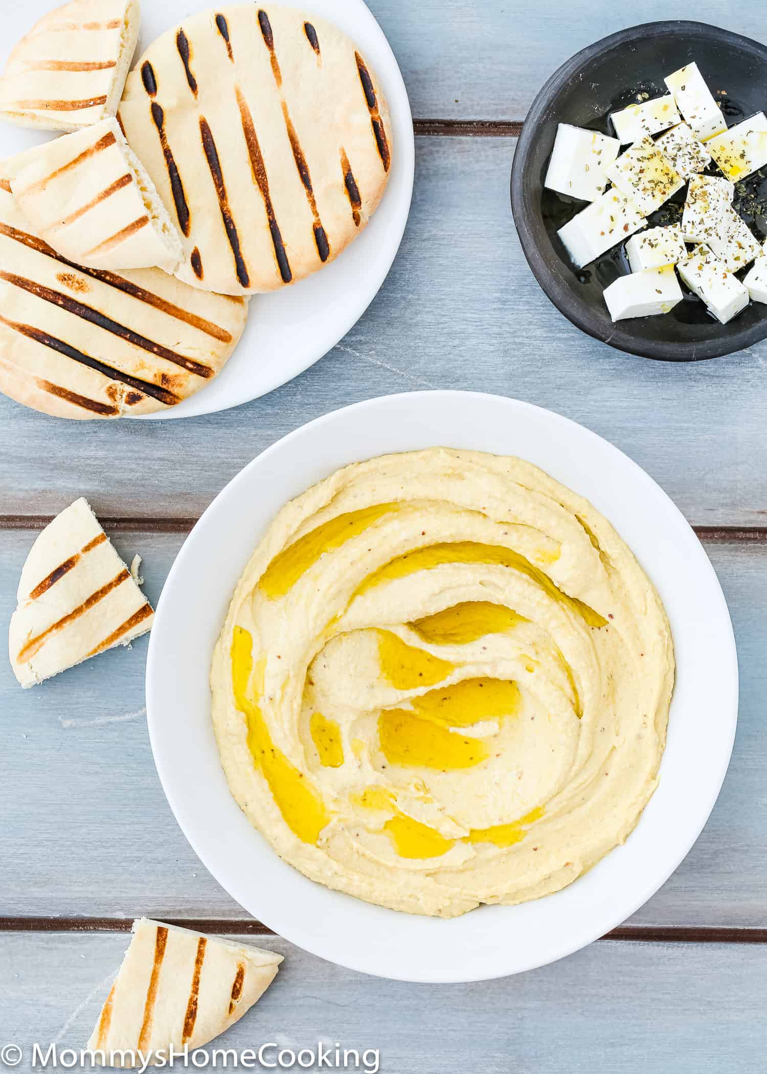 Easy Mustard Hummus in a bowl over a blue wooden surface. 