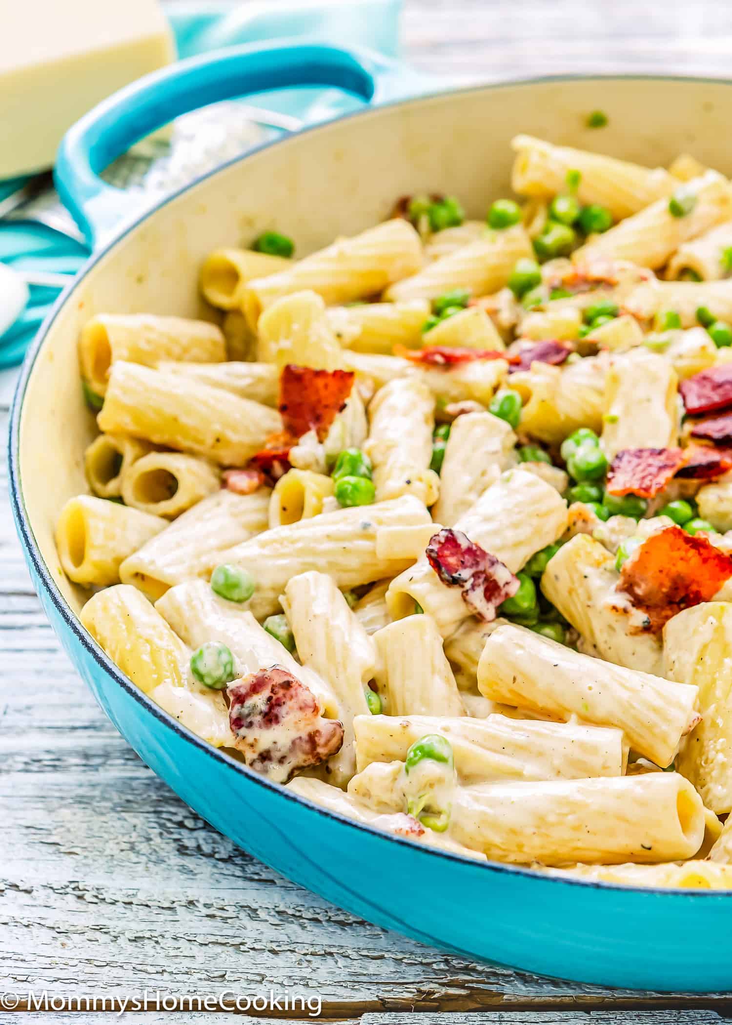 Creamy Alfredo Pasta with bacon and peas in a large pot.