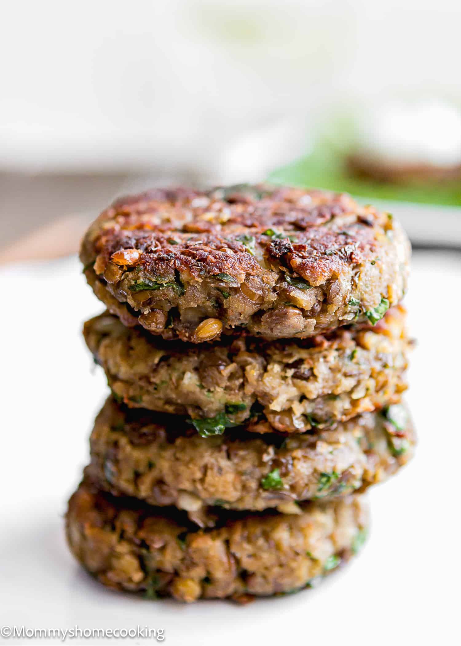 four Healthy Easy Lentil Patties stack on a white plate.