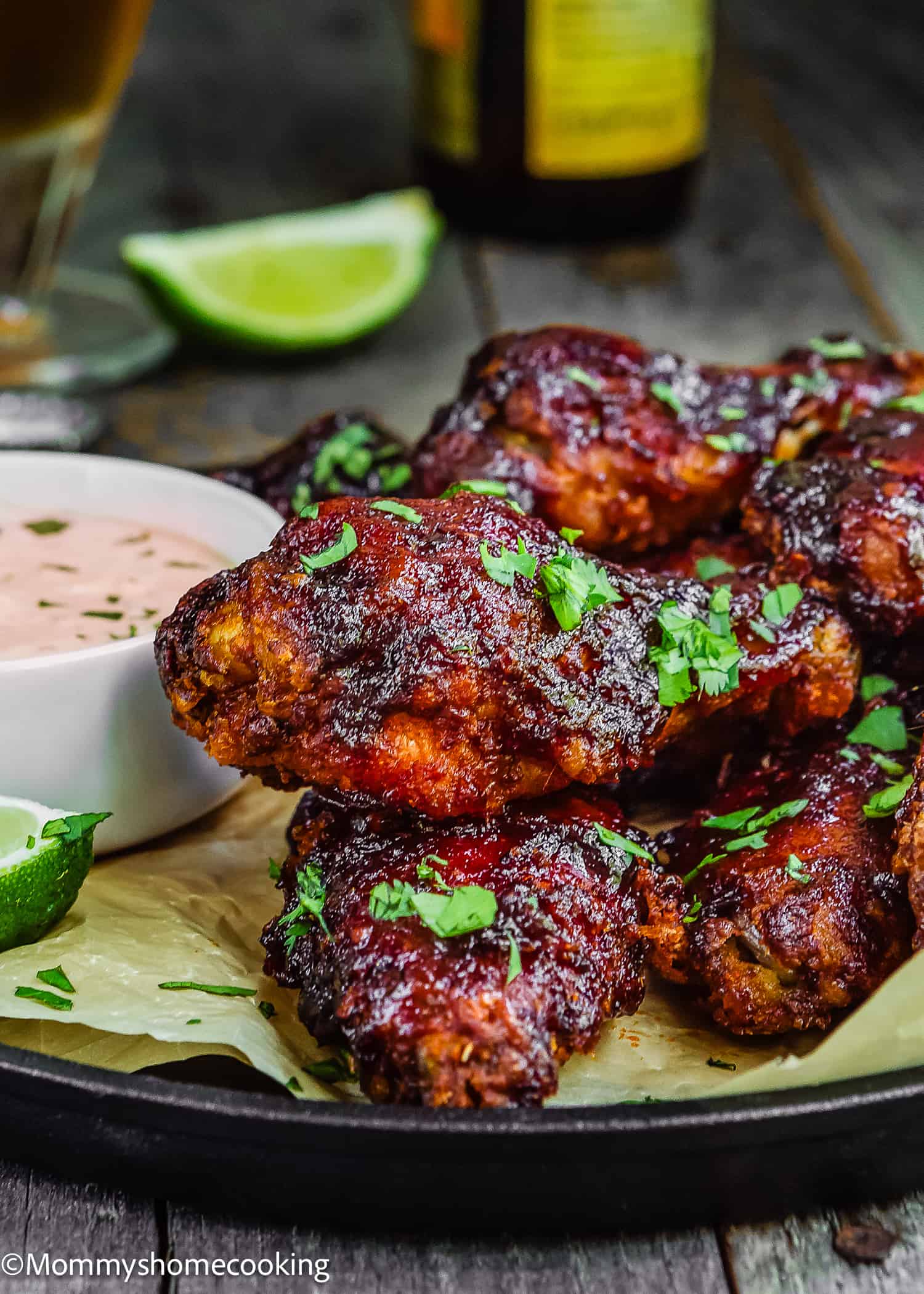 Chipotle Chicken Wings on a plate with chipotle sauce and a lime wedges on the side.