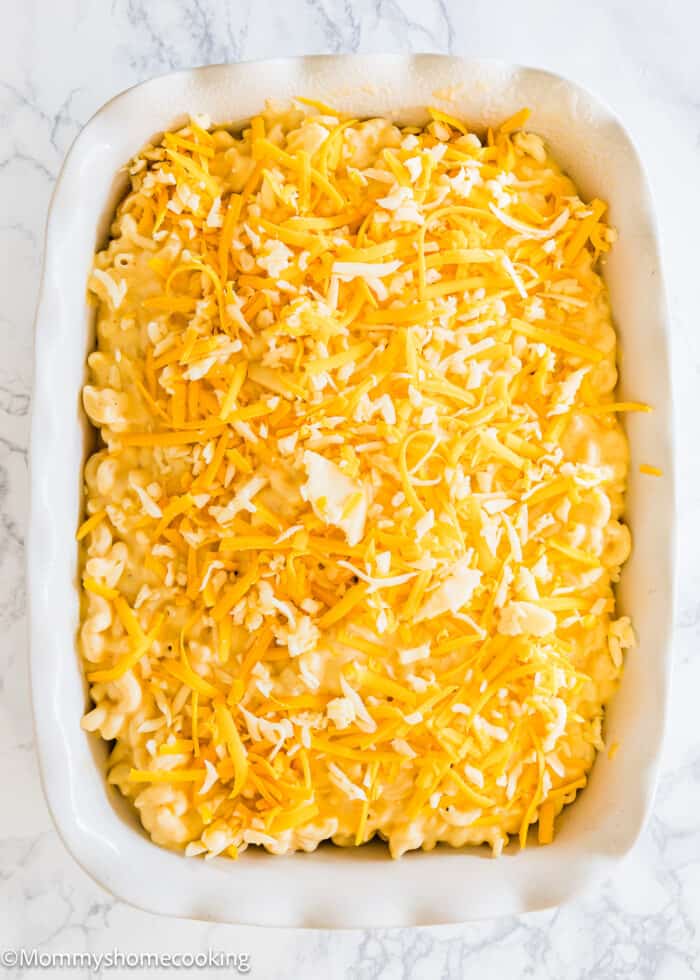 a baking dish with one layer of mac and cheese topped with more cheese, and another layer of mac and cheese and more cheese on the top.