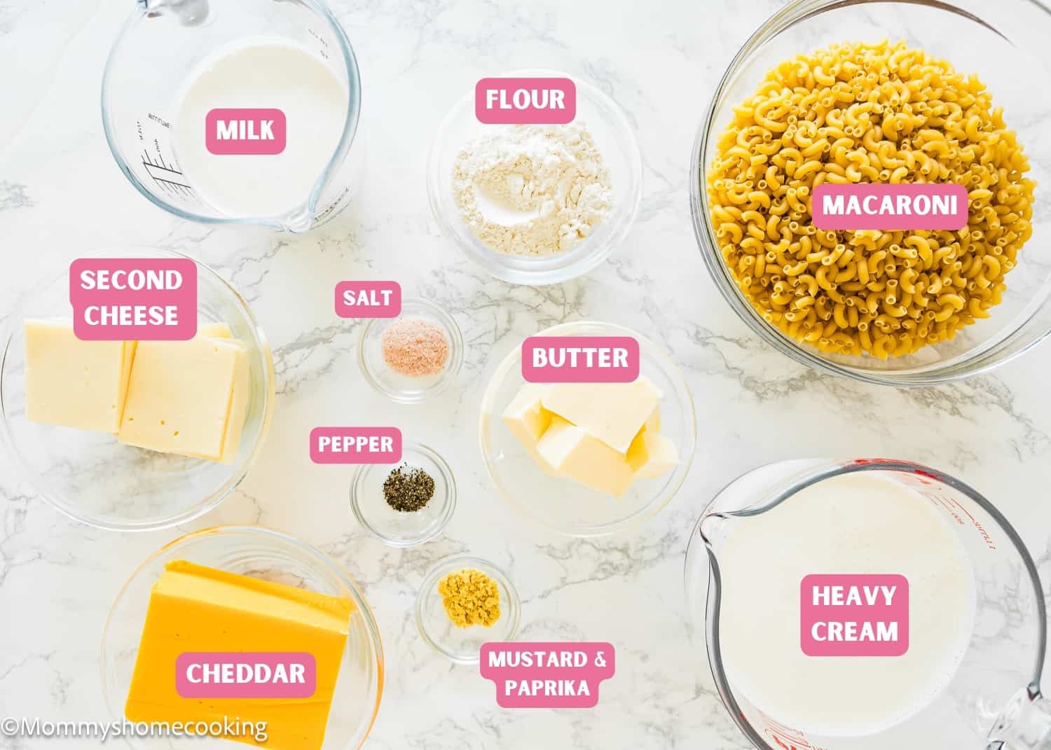 Ingredients needed to make mac and cheese over a marble surface.