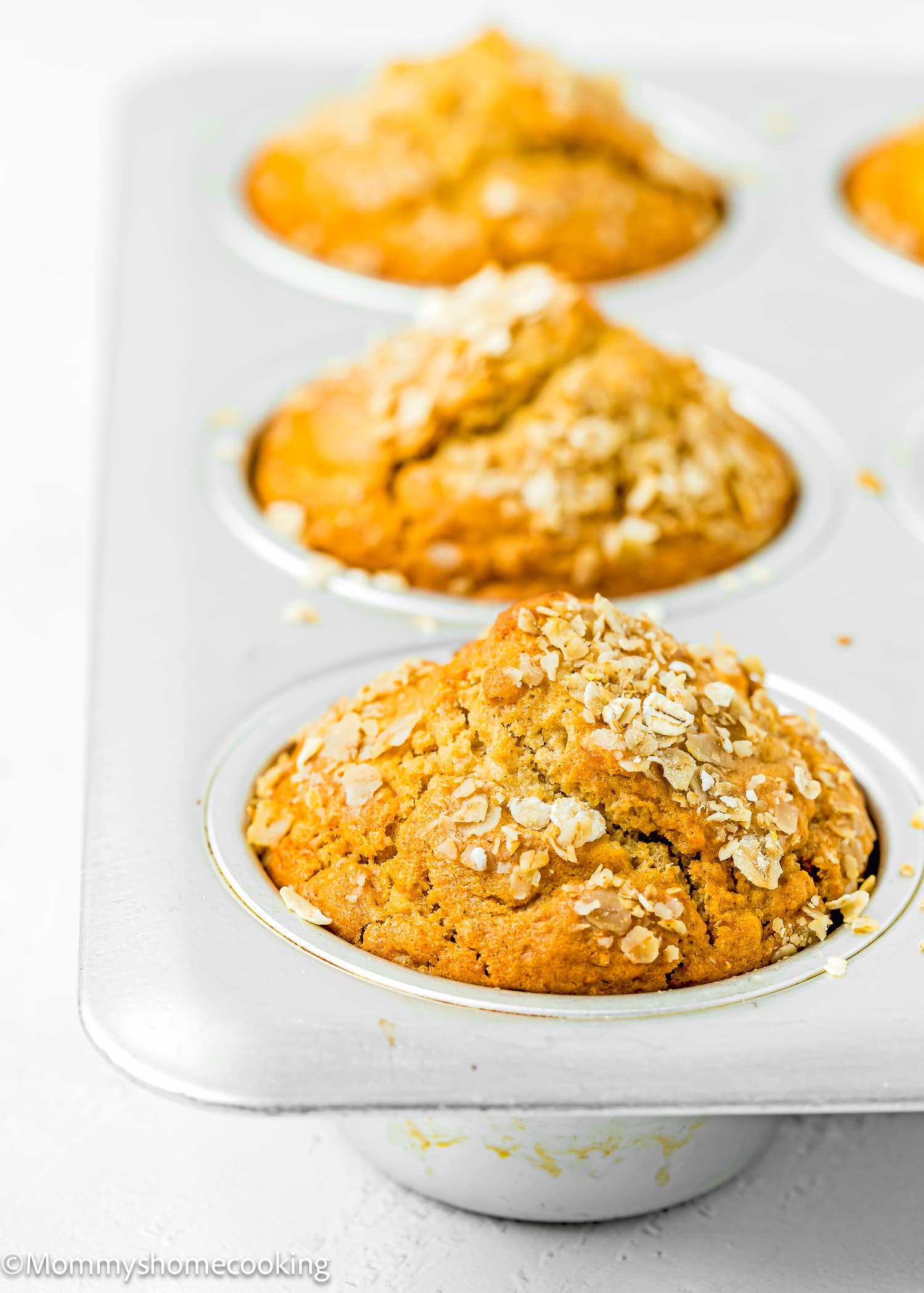 Delicious healthy oat muffins in a tin topped with oats, made without eggs, dairy or sugar.