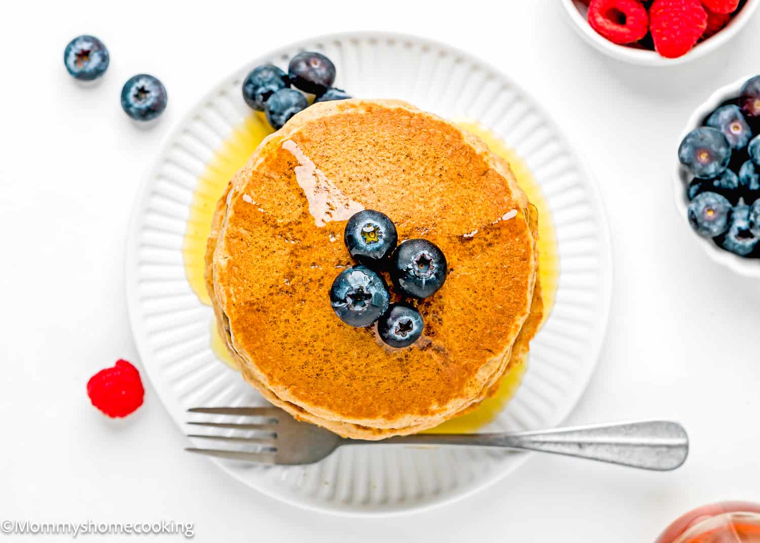 overhead view of a plate with Whole Wheat Pancakes with fresh berries and syrup.