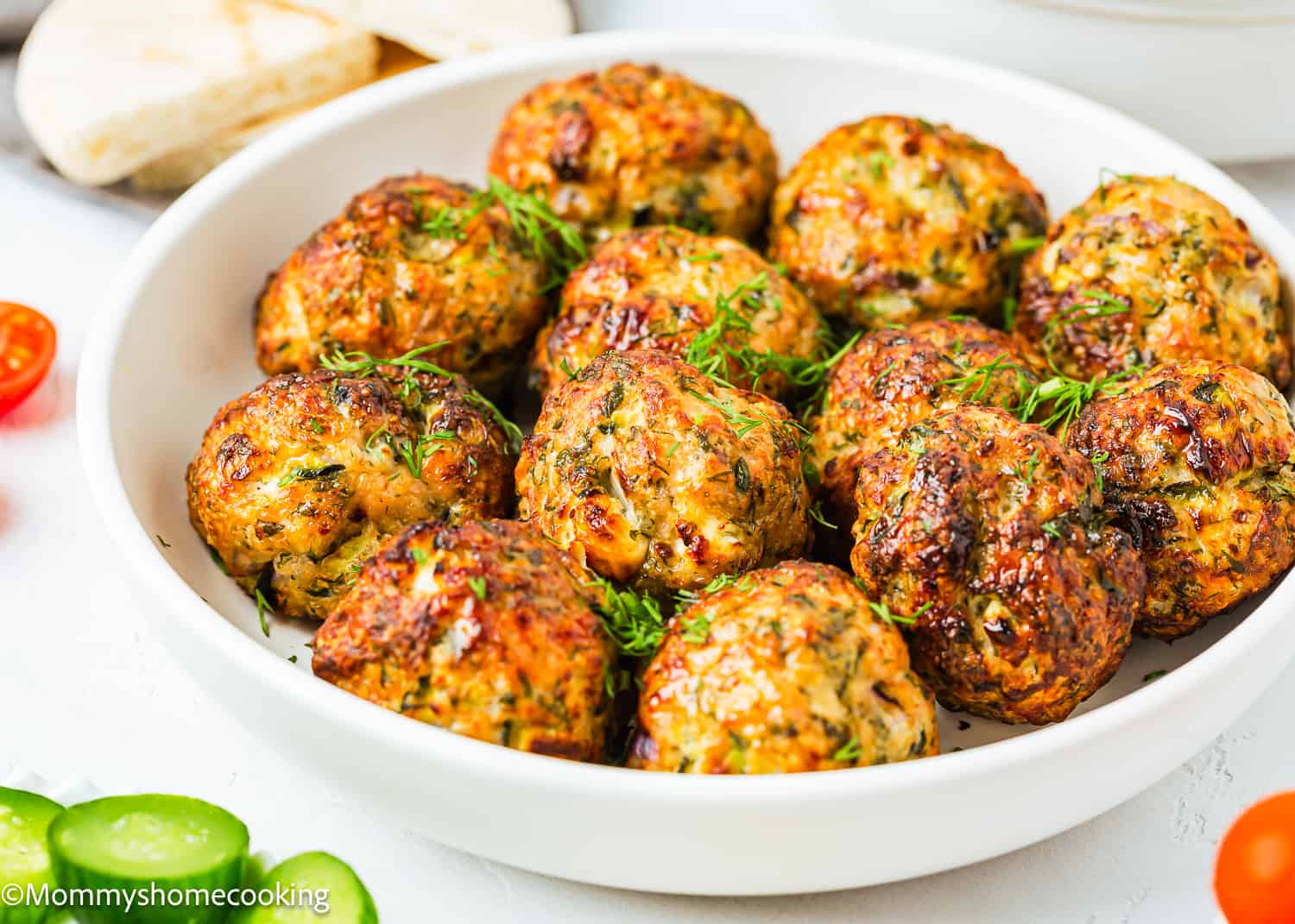 baked Greek Chicken Meatballs on a plate and garnished with fresh dill.