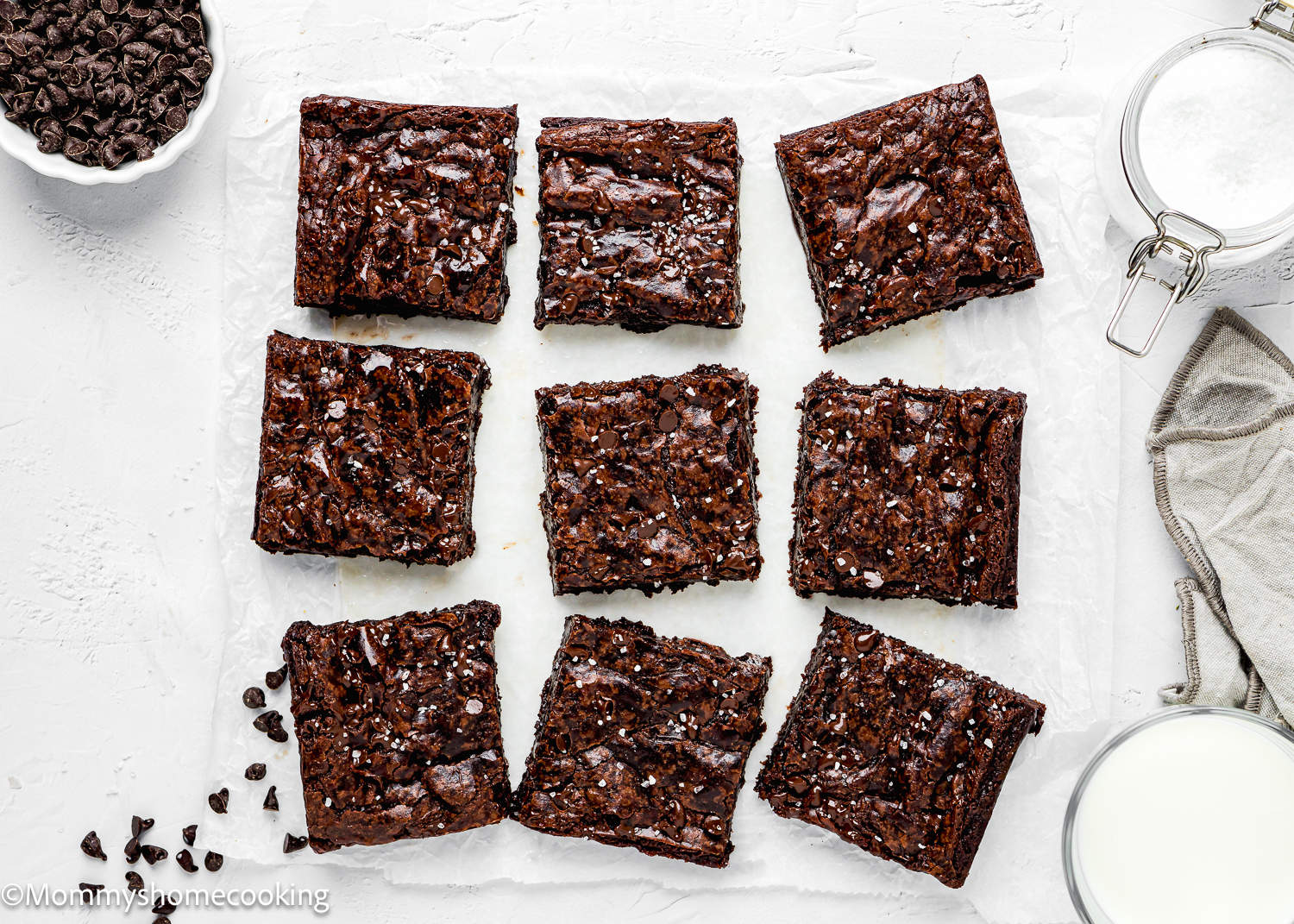 Six squares of boxed eggless brownies on a sheet of paper.