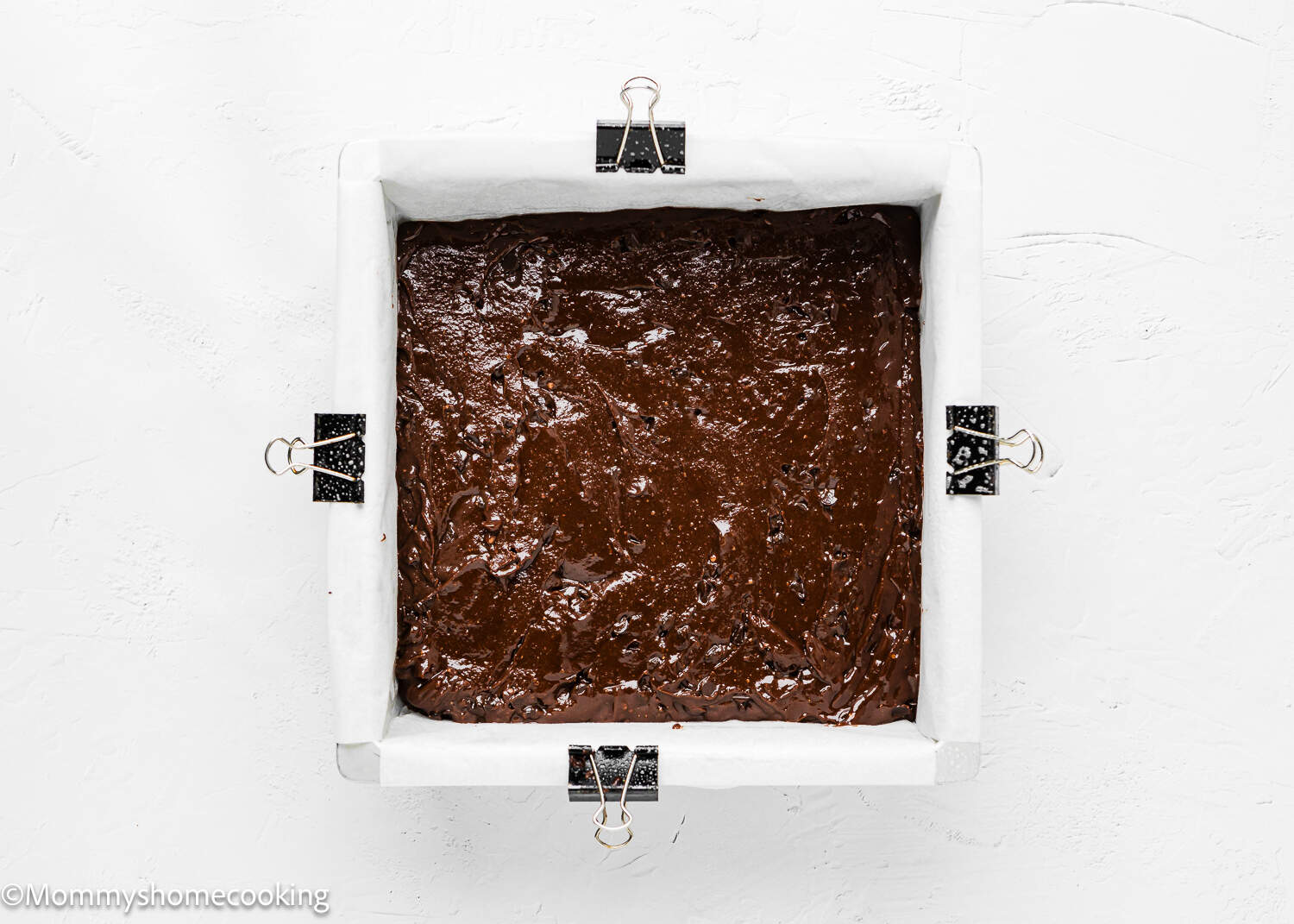 A boxed brownie batter made without eggs in a baking pan on a white surface.