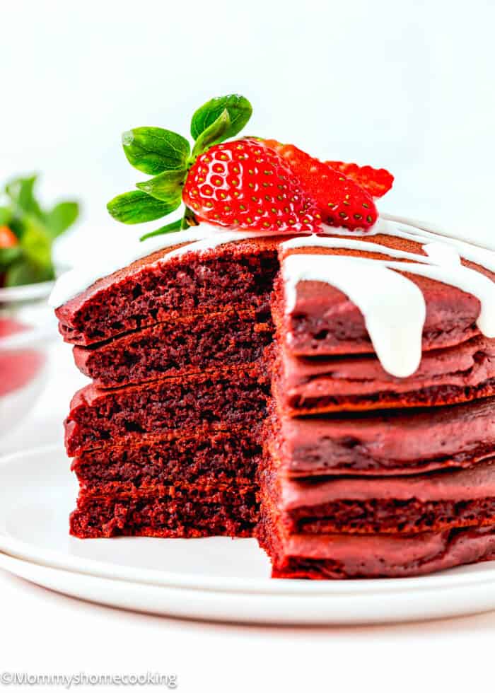 cut five eggless red velvStack of five egg-free red velvet pancakes cut, showing their fluffy inside texture.et pancakes stack showing their fluffy inside texture.