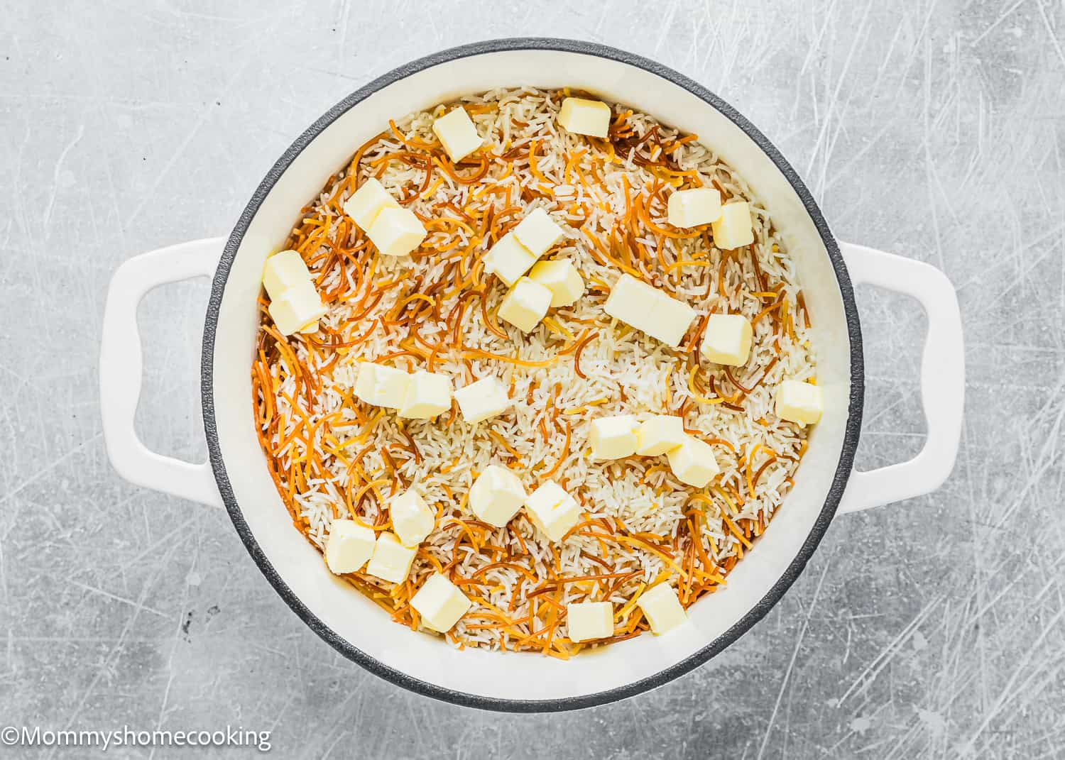 Vermicelli Rice (Arroz con Fideos) in a dutch oven with cubed butter on top.