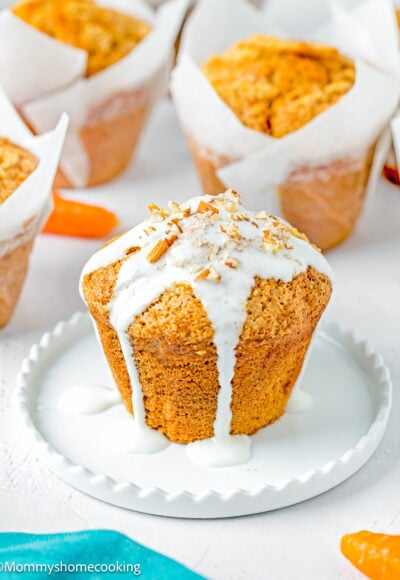a Carrot Cake Muffin (No Eggs & No Dairy) with glaze on a white plate.