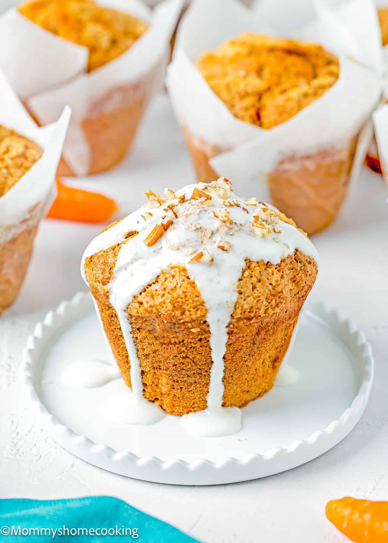a Carrot Cake Muffin (No Eggs & No Dairy) with glaze on a white plate.