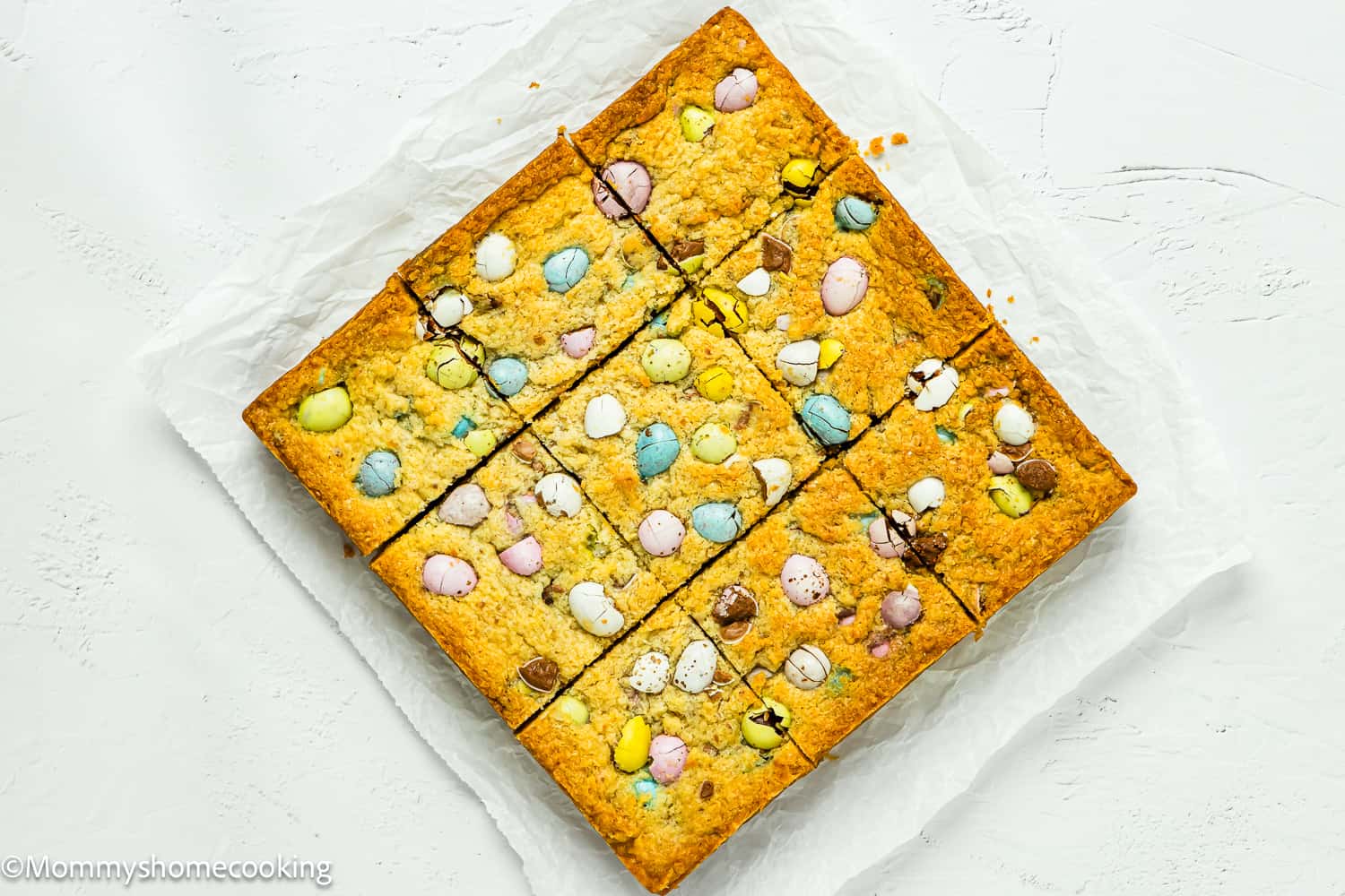 cut into square Easter Blondies over a piece of parchment paper.