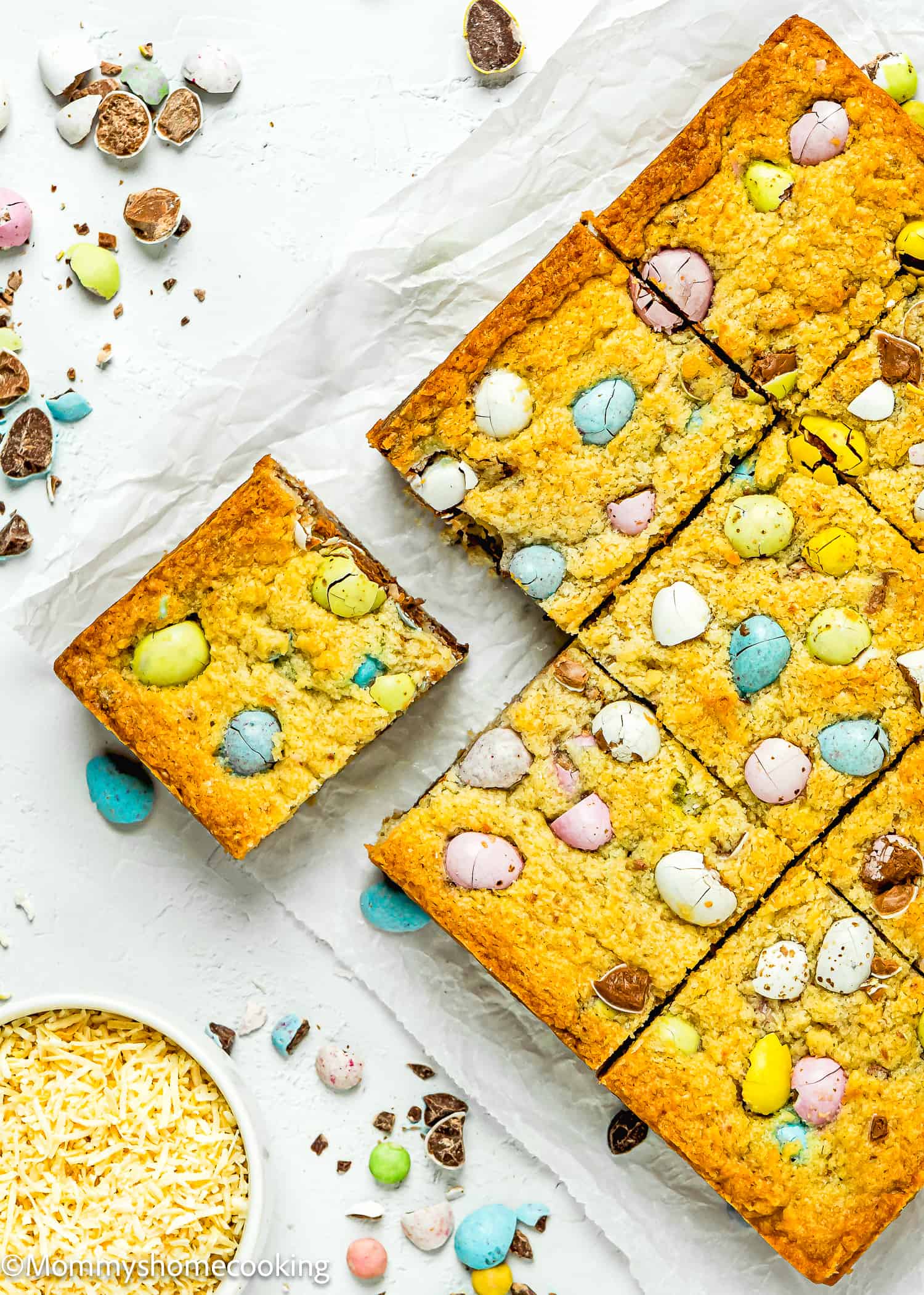 cut into square Easter Blondies made without eggs over a white surface.