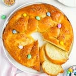 a sliced Easter Sweet Bread over a plate with sprinkles and easter chocolate mini eggs.