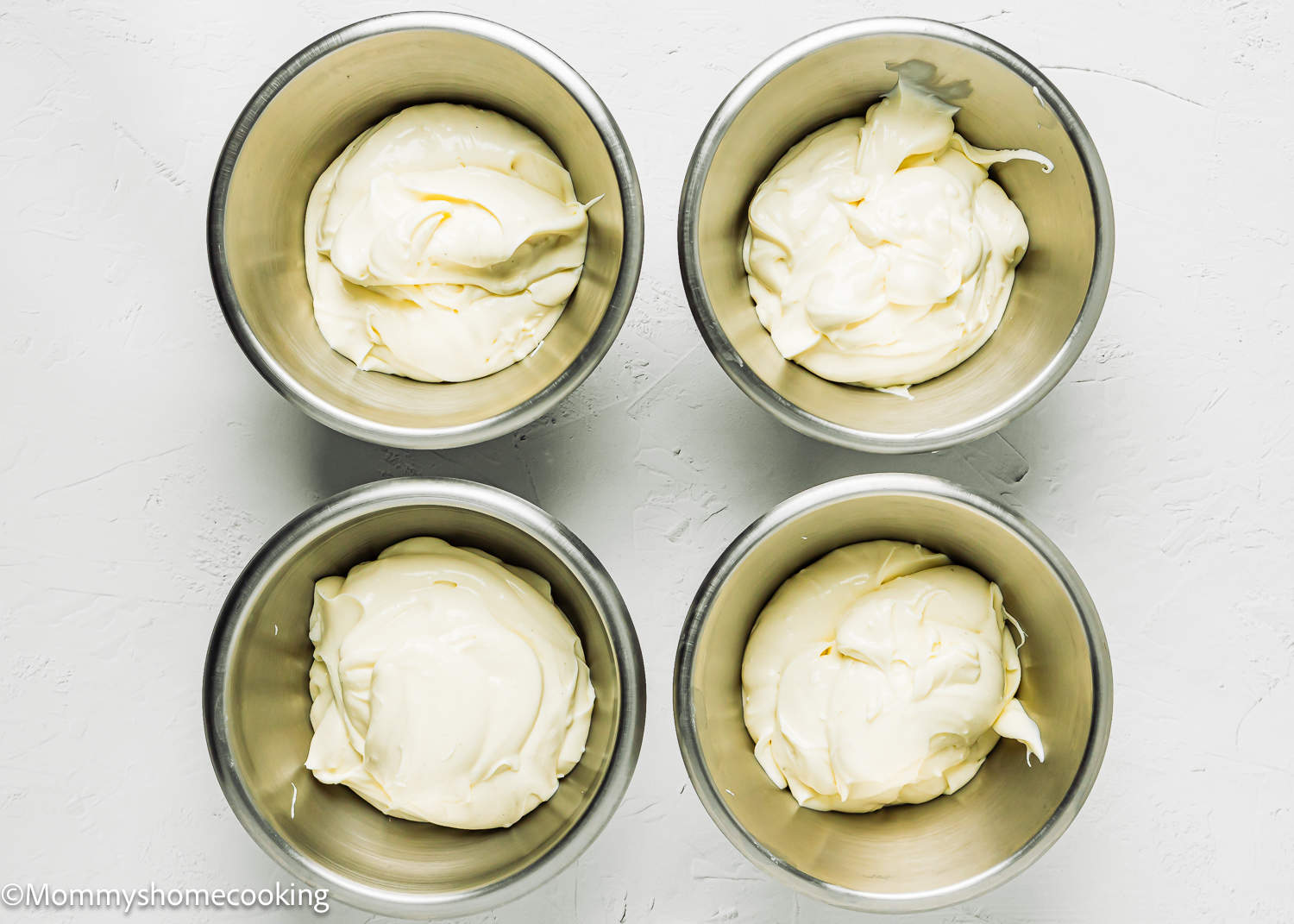 four metals bowls with egg-free cheesecake batter.