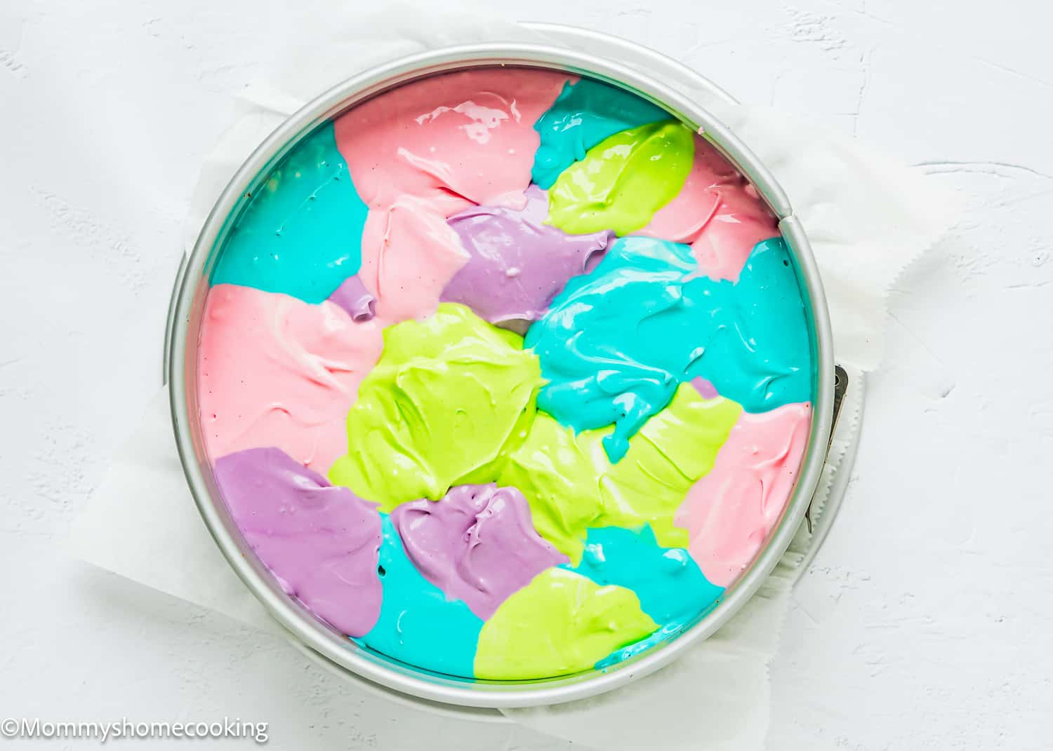 unbaked colorful cheesecake in a springform pan.