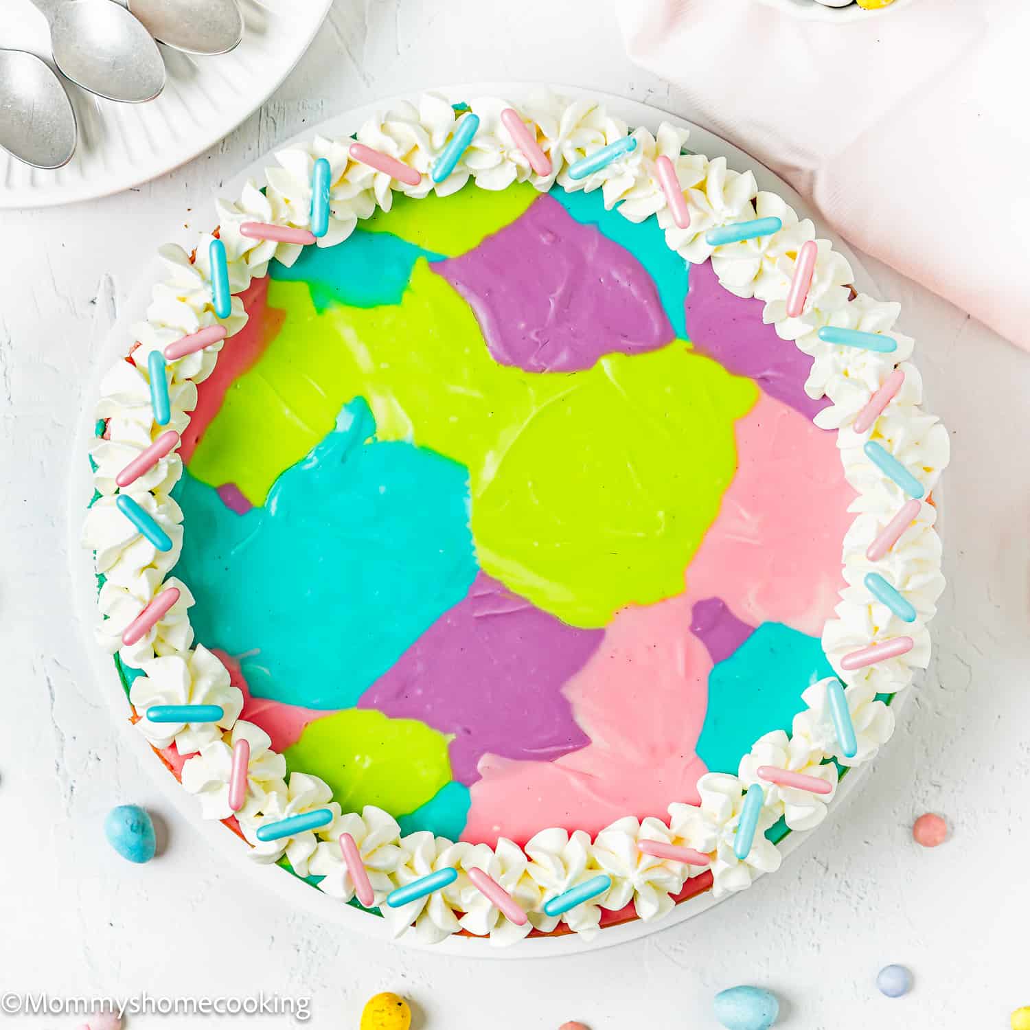 Easy Baked Easter Cheesecake (Egg-free) over a white surface with chocolate eggs and sprinkles.