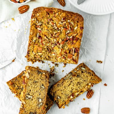 An Easy Banana Nut Bread Without Eggs sliced over a piece of parchment paper.