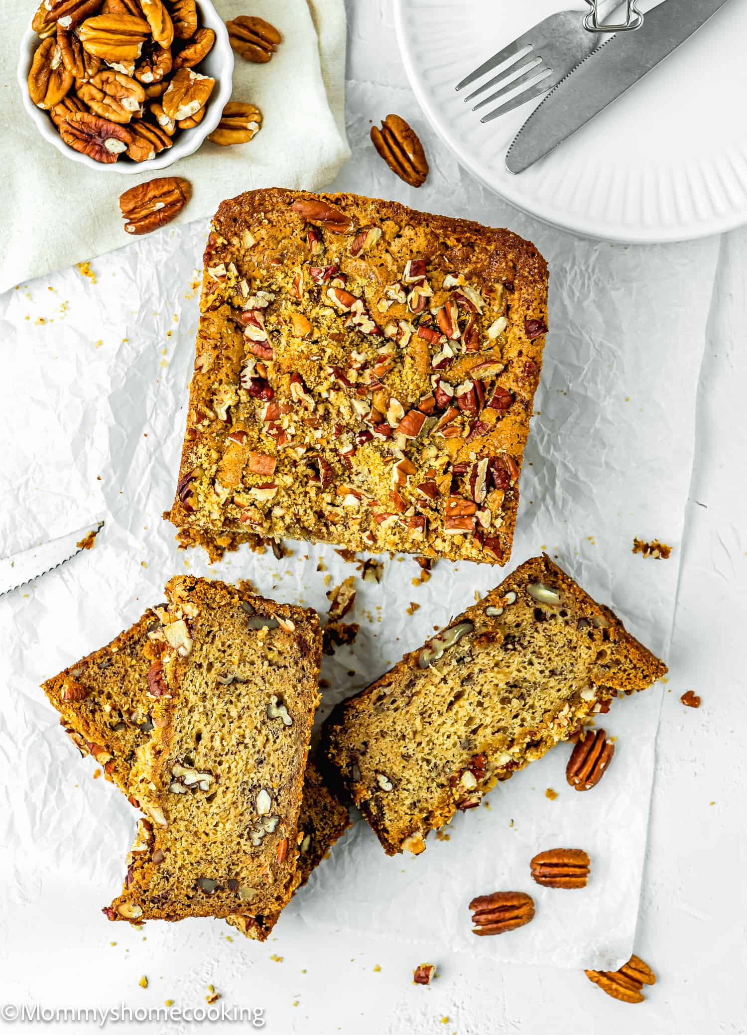 An Easy Banana Nut Bread Without Eggs sliced over a piece of parchment paper.