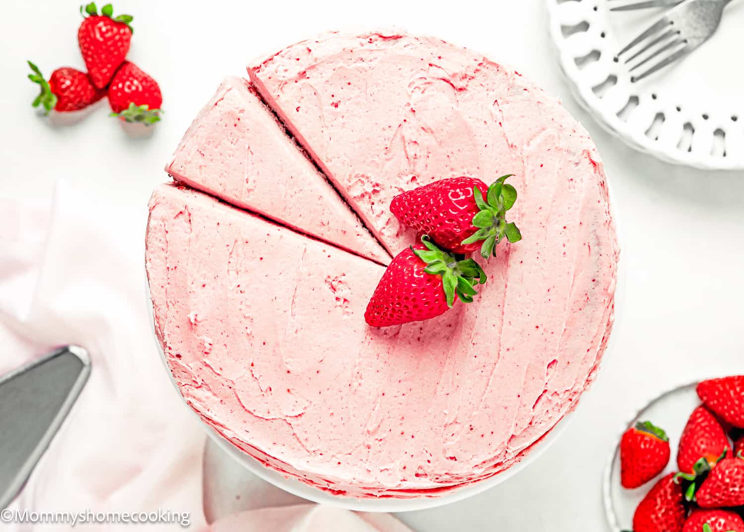 Overhead view of a Easy Fresh Strawberry Cake with strawberry frosting and fresh strawberries.