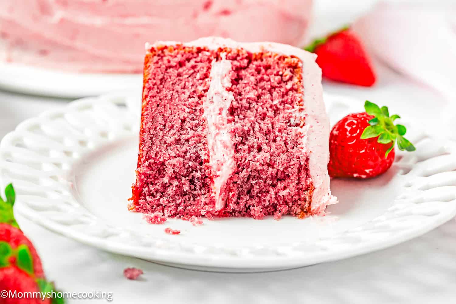 a bitten slice of Easy Fresh Strawberry Cake showing its fluffy inside texture on a plate.