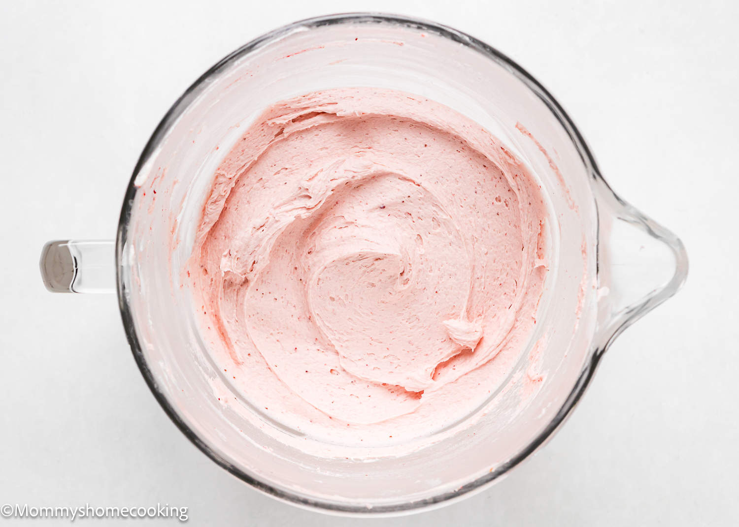 easy homemade strawberry frosting in a stand mixer bowl over a white surface.
