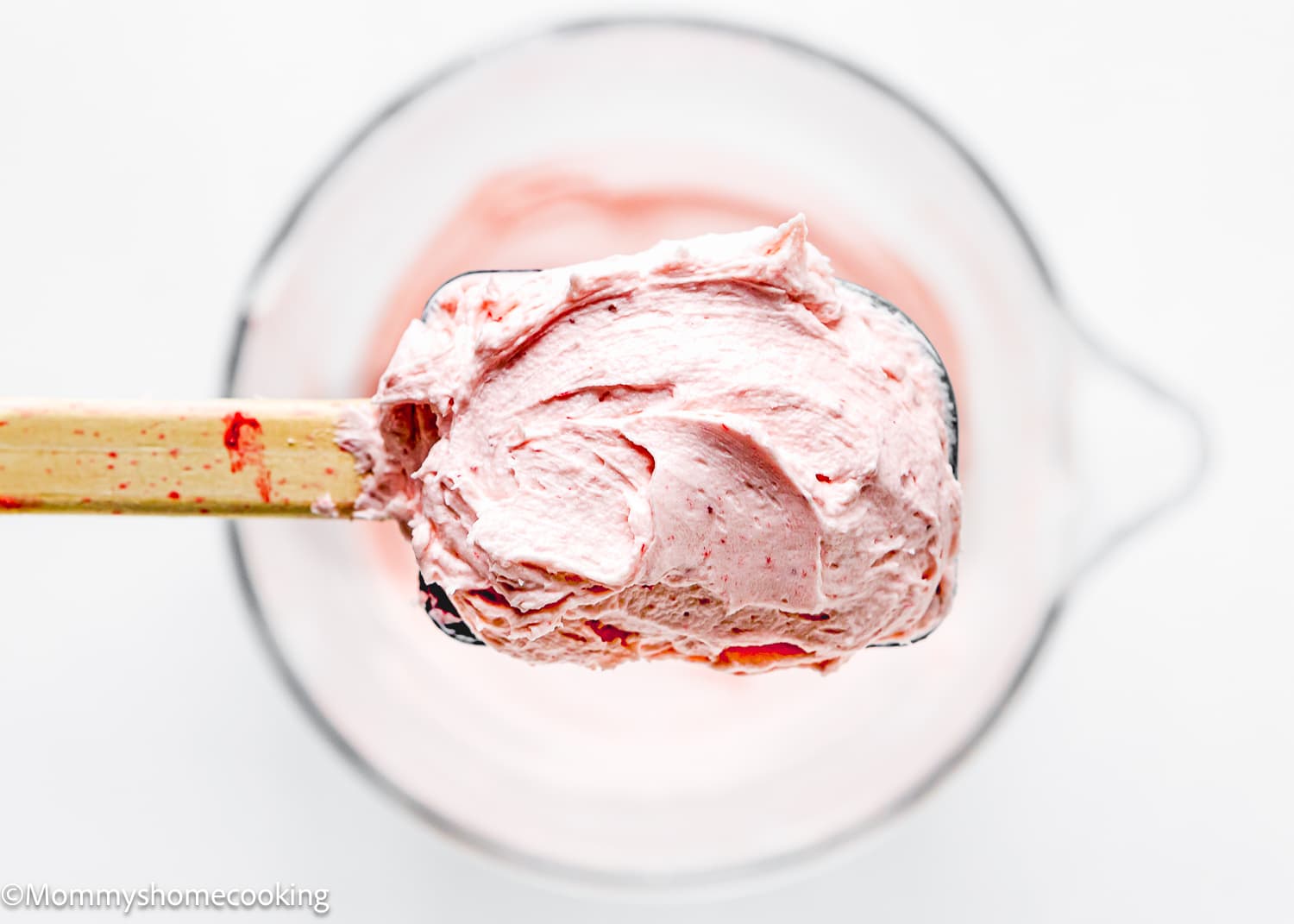 a spatula with easy homemade strawberry frosting.