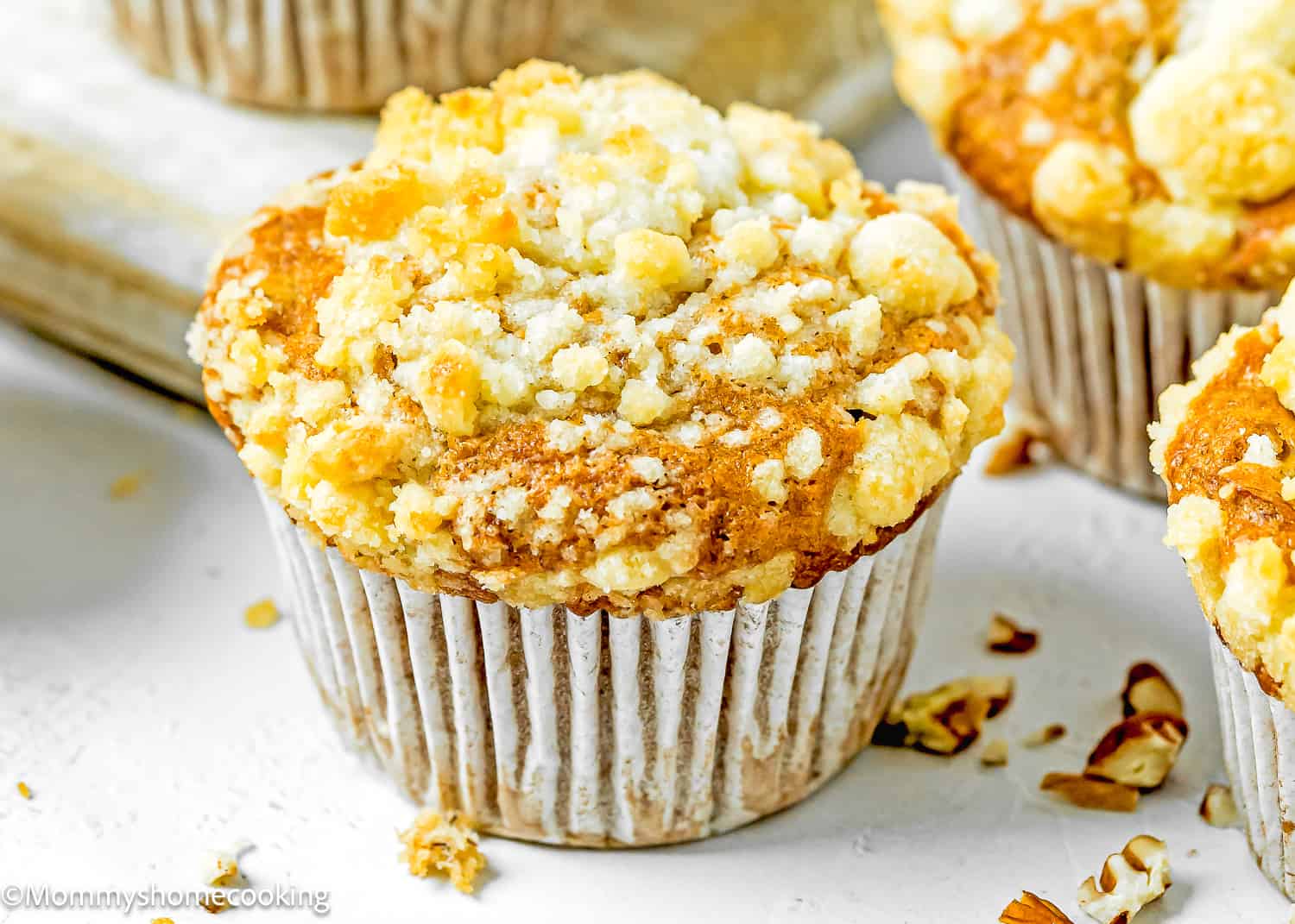 a Hummingbird Muffin with crumb on top on a white surface.