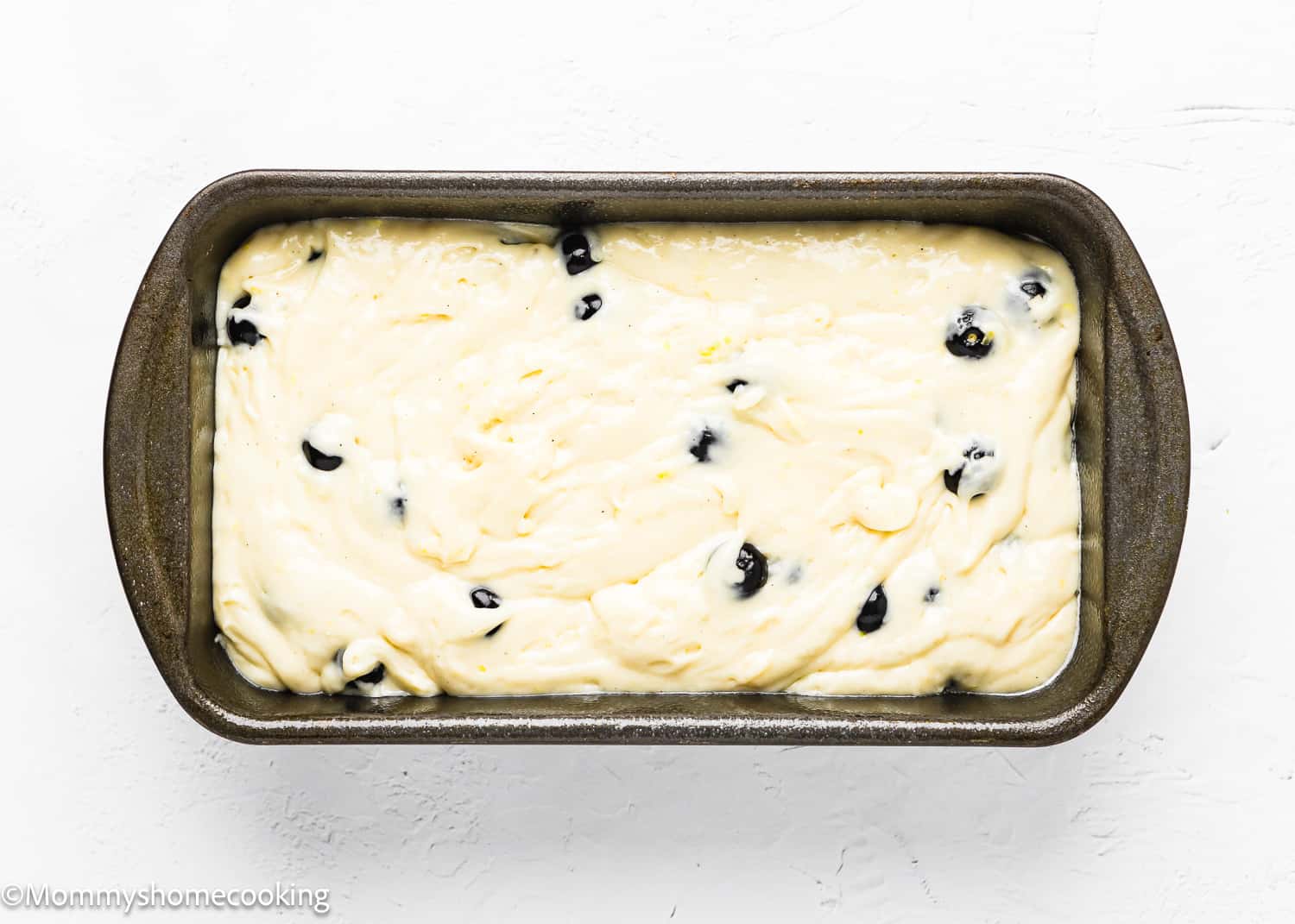 Eggless Lemon blueberry Loaf Cake batter in a loaf pan.