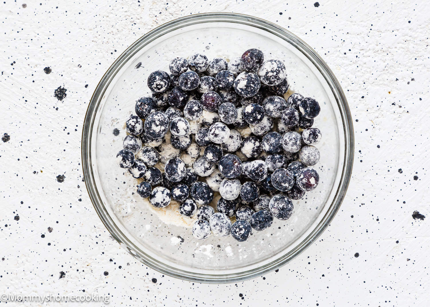 Blueberries and flour in a bowl.