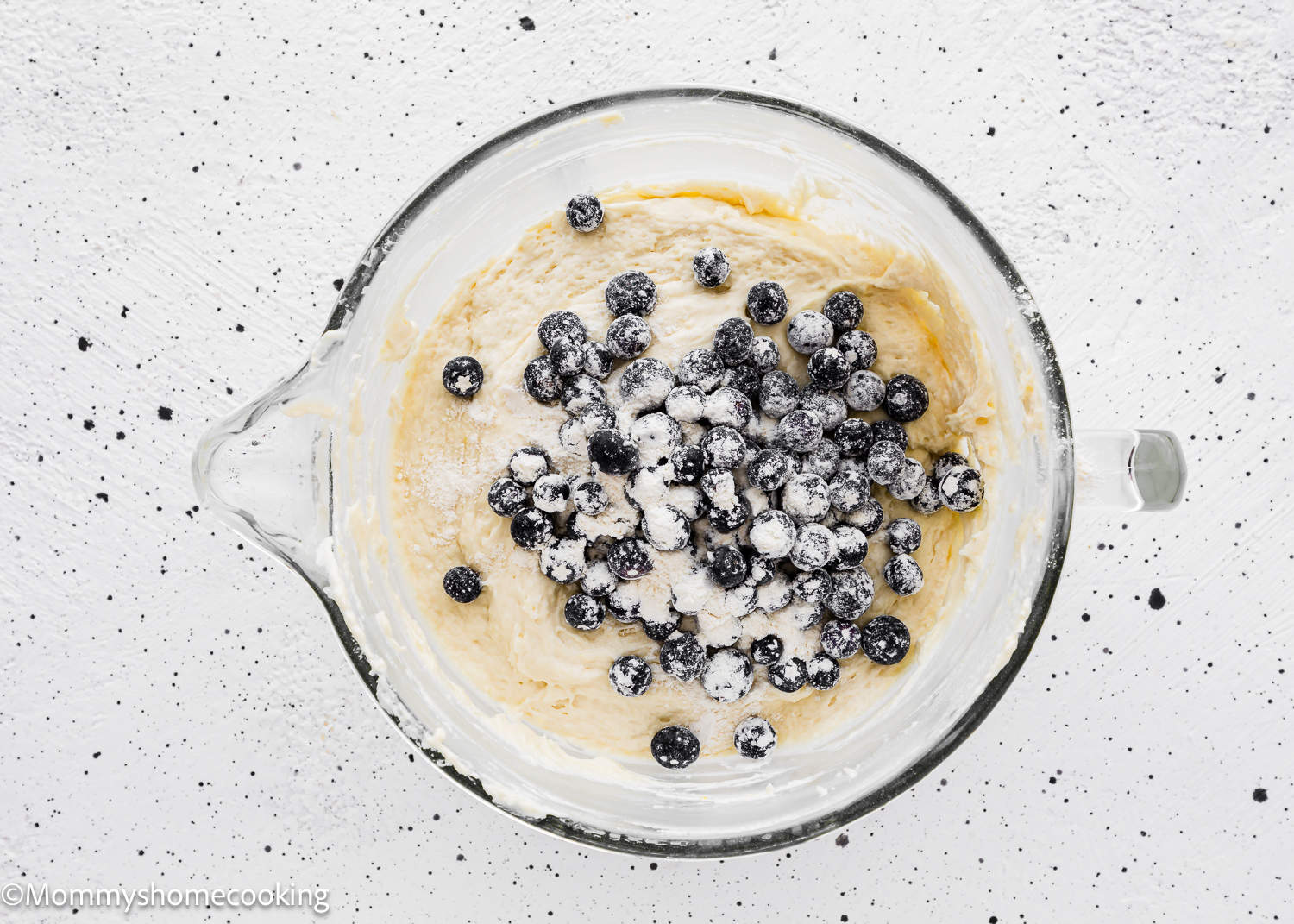 Eggless Lemon blueberry Loaf Cake batter in stand mixer bowl with more blueberries on top.