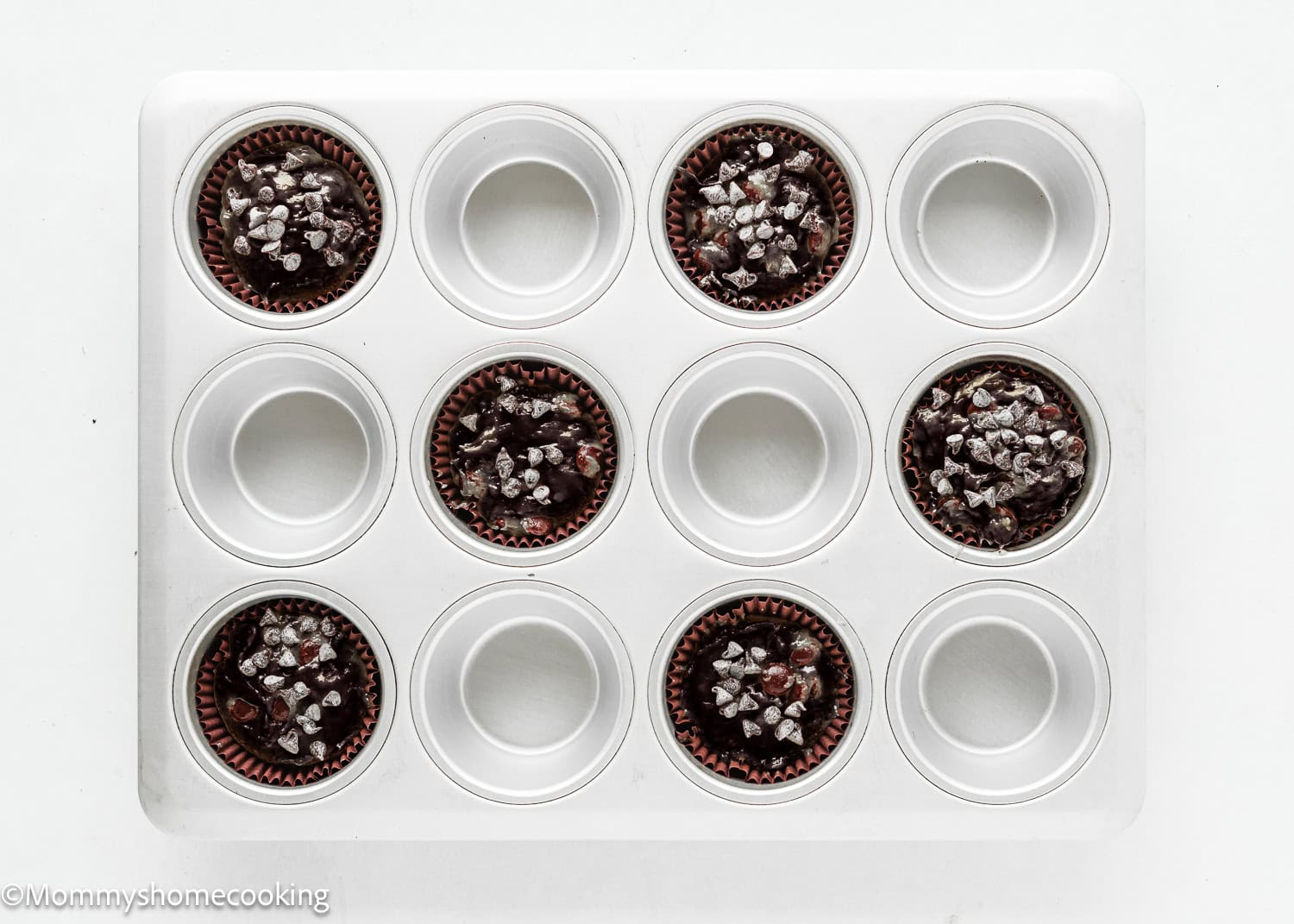 muffin pan with six wells with Bakery-Style Vegan Double Chocolate Muffin batter.