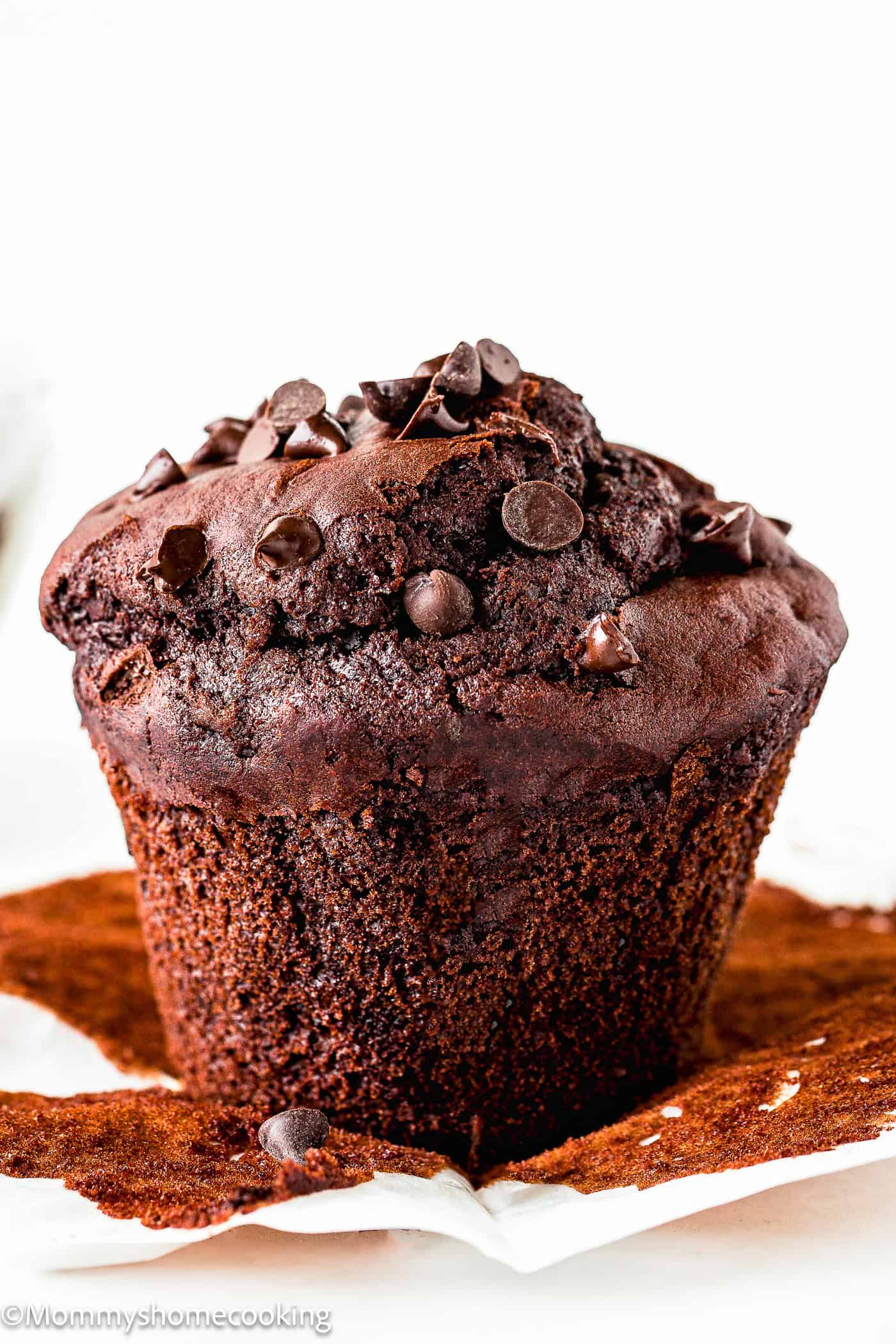 a whole Bakery-Style Vegan Double Chocolate Muffin over a white surface.