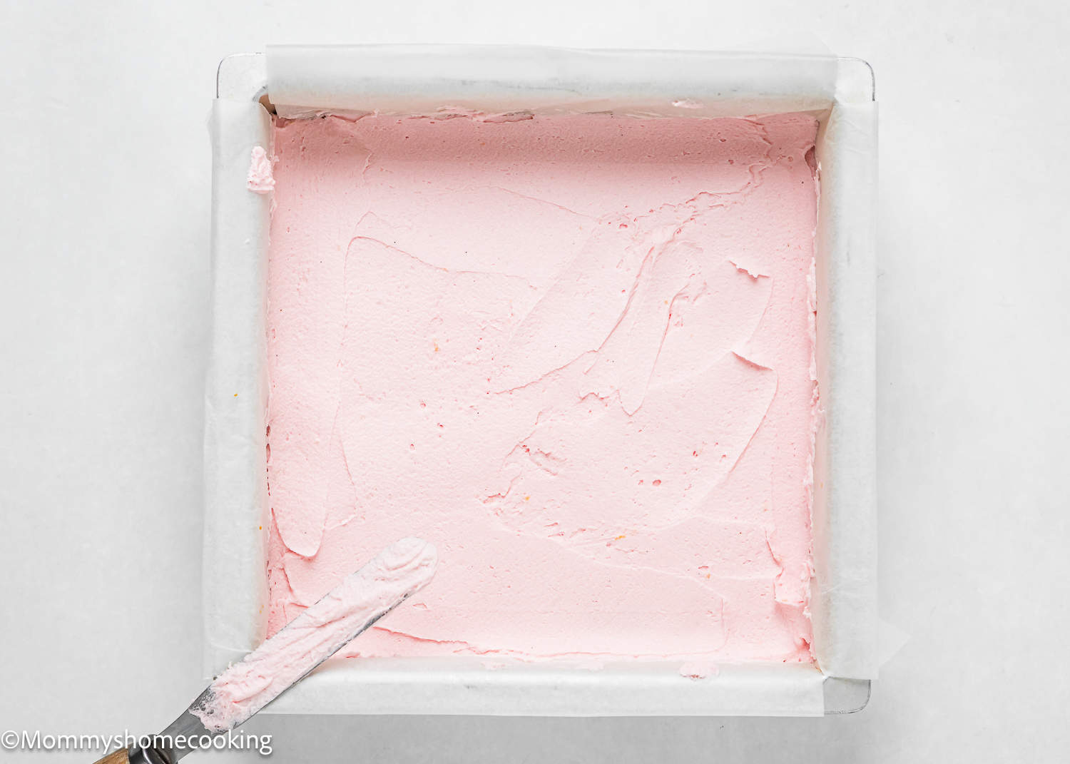 pink frosting covering a slab of egg-free sugar cookie bars.