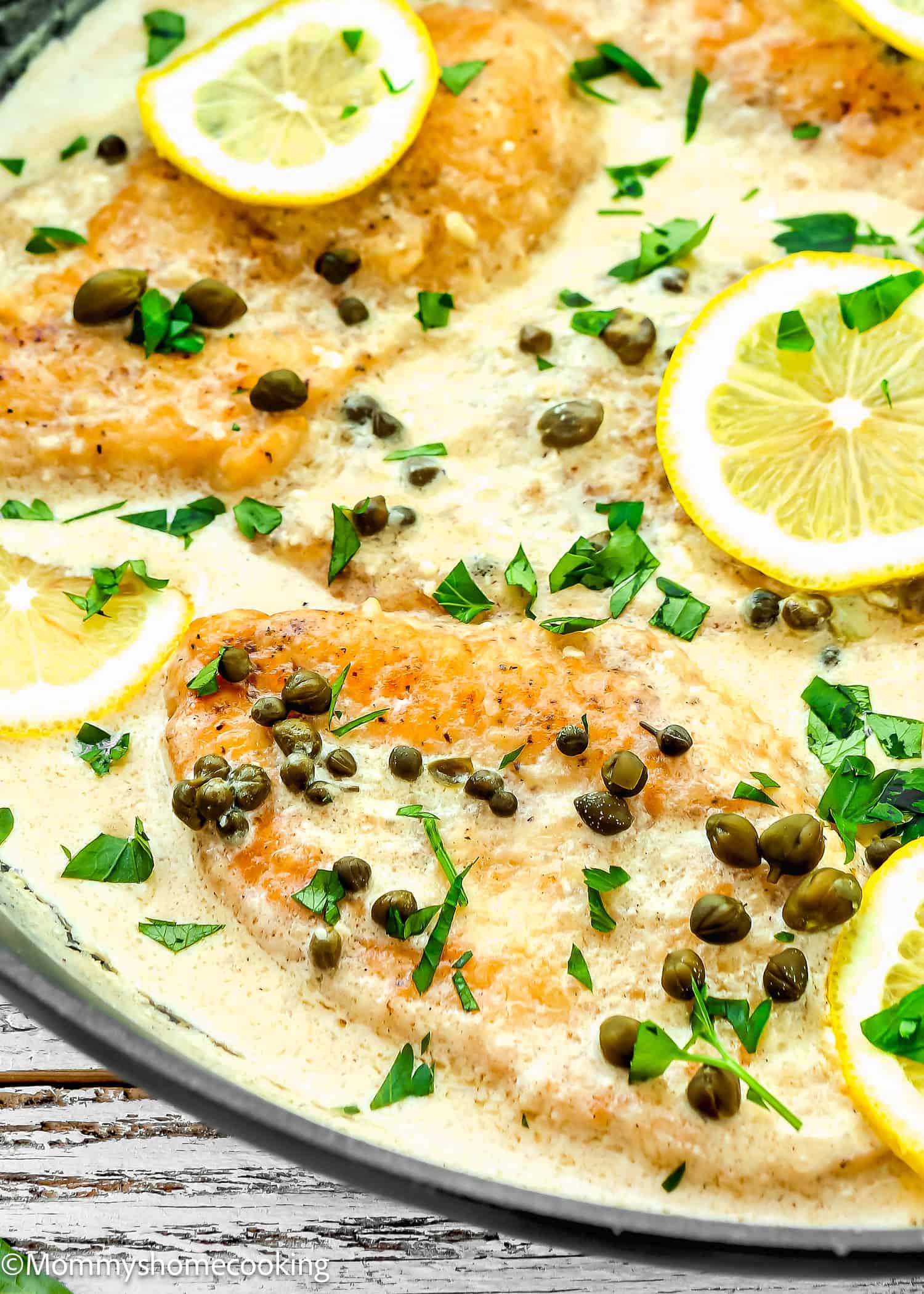 Easy Chicken Piccata in creamy sauce with lemon slices and capers.
