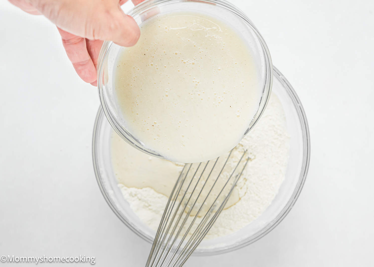 a hand mixing ingredients to make dairy free egg-free Vanilla Cupcakes batter.