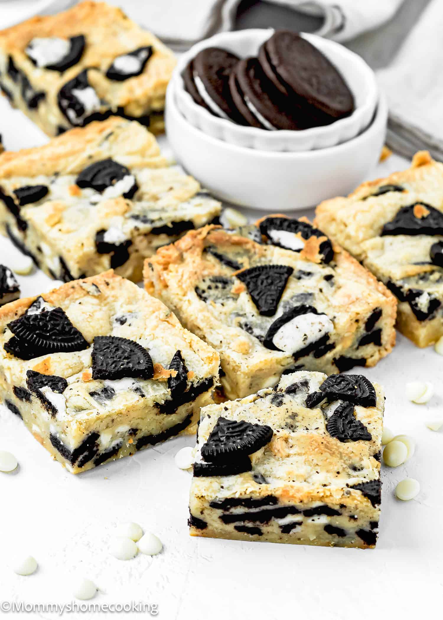 eggless Easy Oreo Blondies over a white surface with a bowl with oreos on the back.