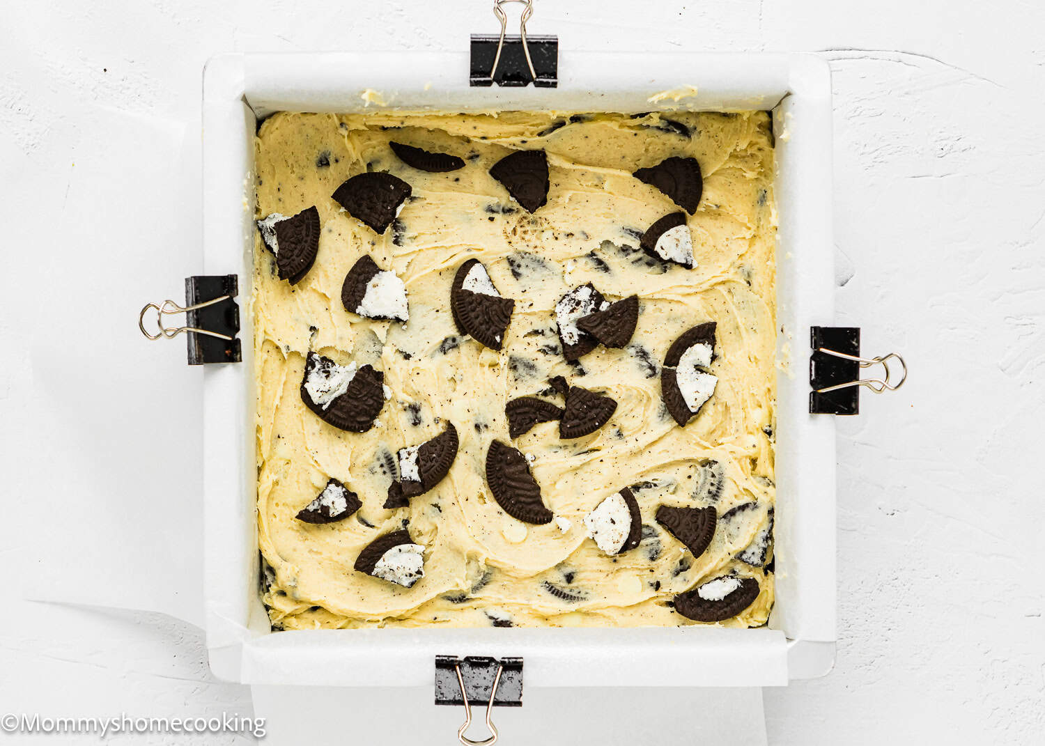 eggless Easy Oreo Blondies batter with more oreos on top in a baking pan.