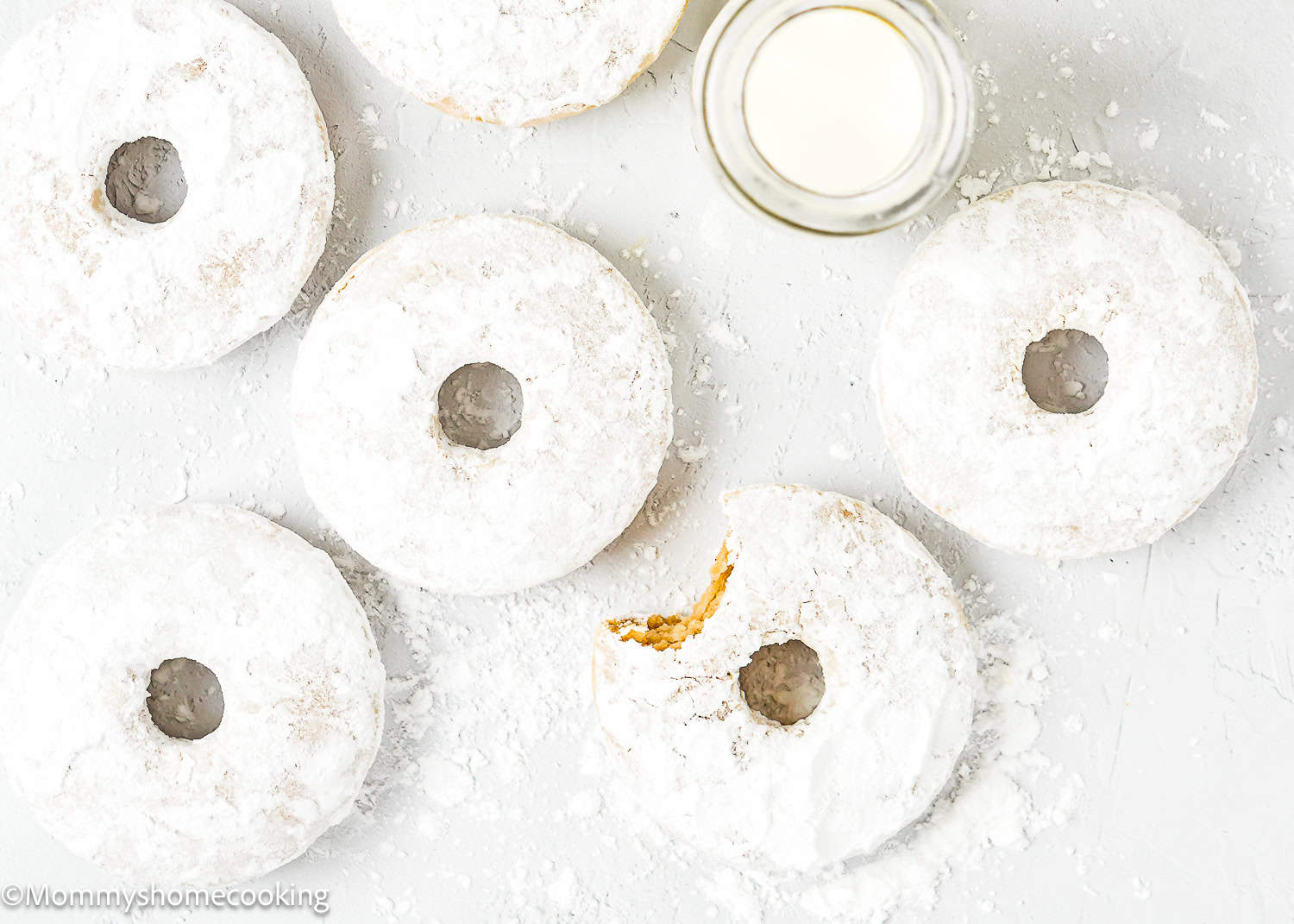 Egg-free Old Fashioned Powdered Sugar Donuts over a white surface.