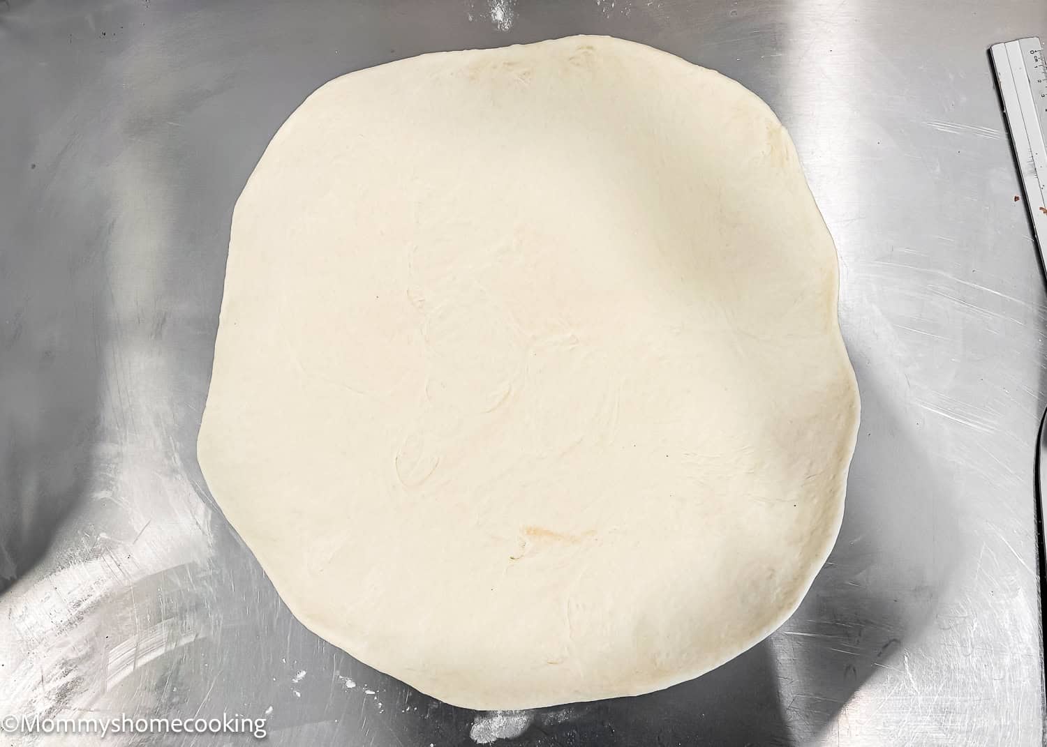 Homemade Eggless Crescents Roll dough roll out over a metal table.