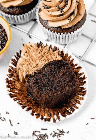 An Easy Vegan Chocolate Cupcake cut in half showing its perfect fluffy inside texture over a white surface.