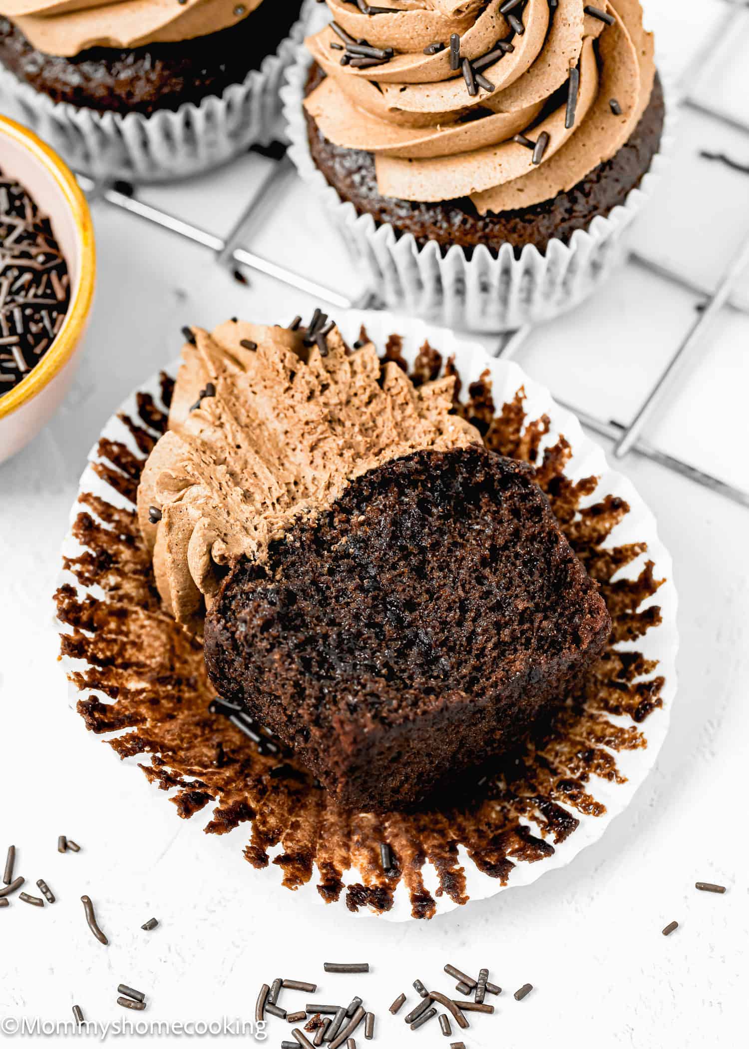 An Easy Vegan Chocolate Cupcake cut in half showing its perfect fluffy inside texture over a white surface.